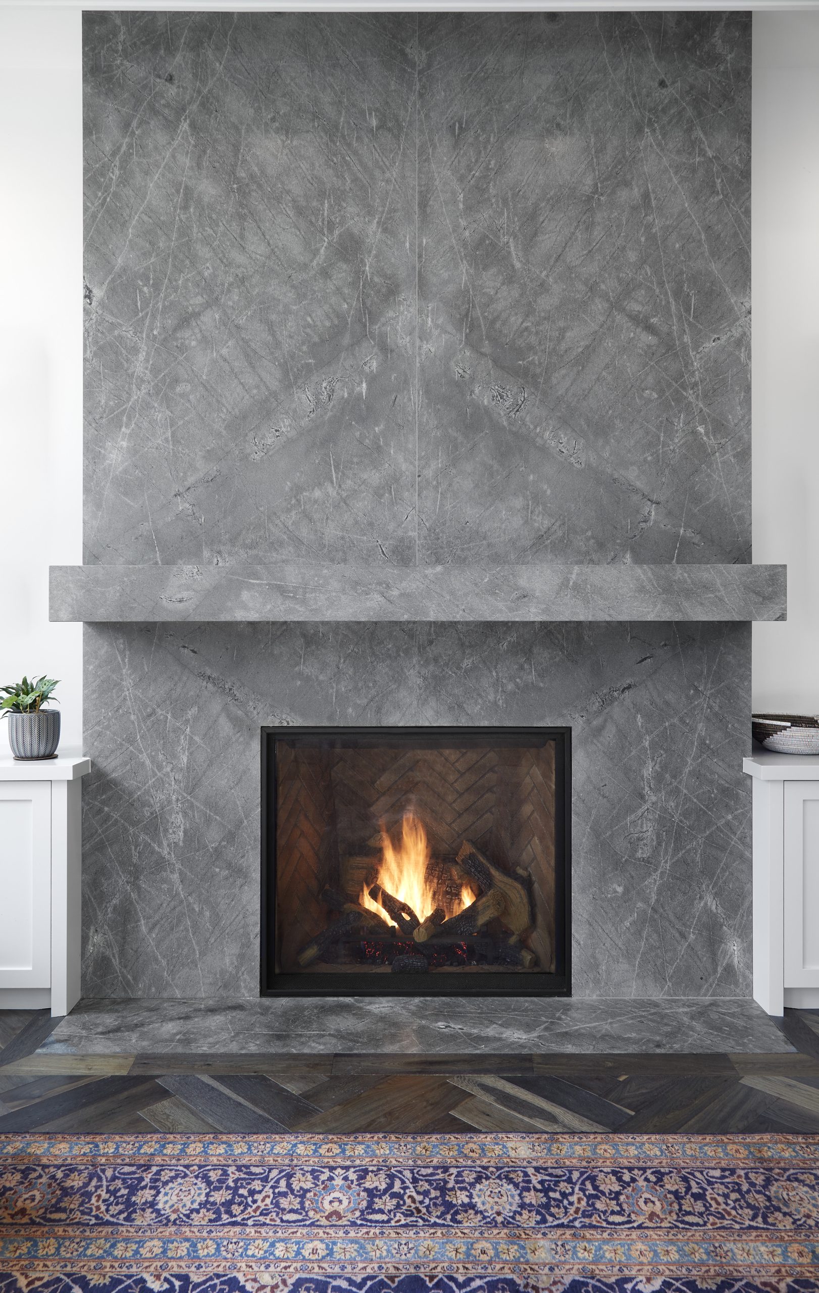 Dark herringbone floors leading through a paneled hallway