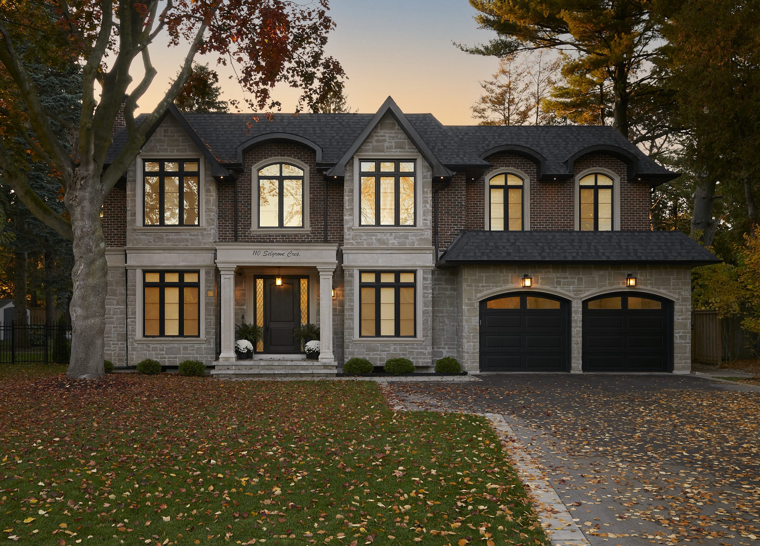 European Manor with red brick, limestone details and a curved roofline