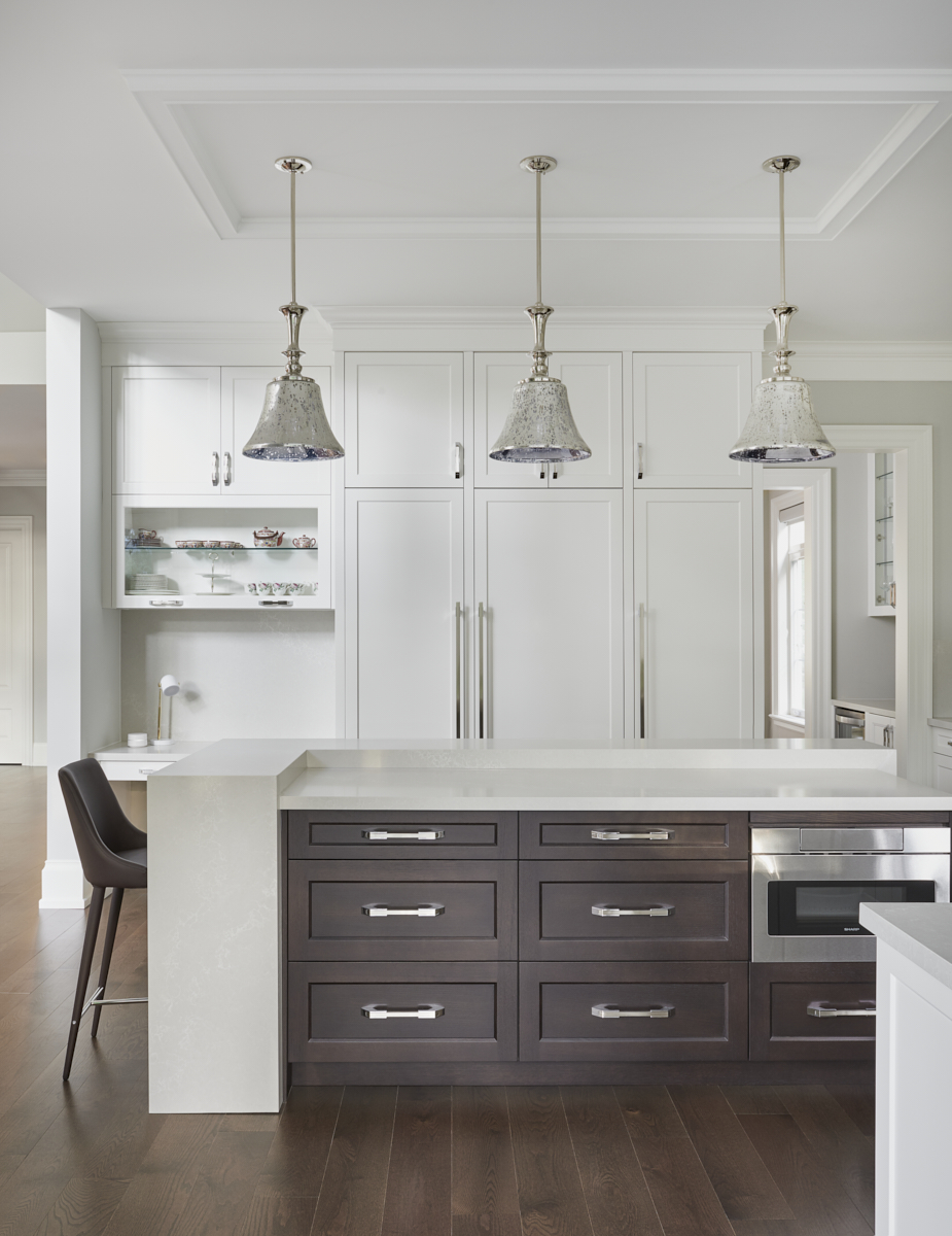 Dark wood kitchen island beneath glass pendants