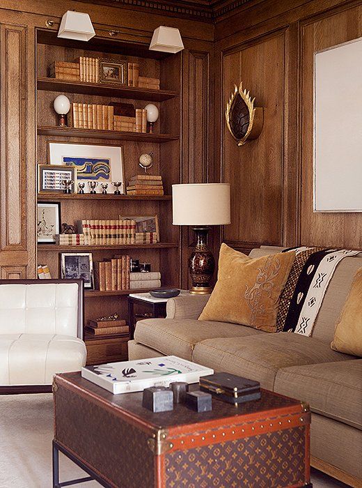 Louis Vuitton trunk used as a coffee table in a wood-panelled sitting room