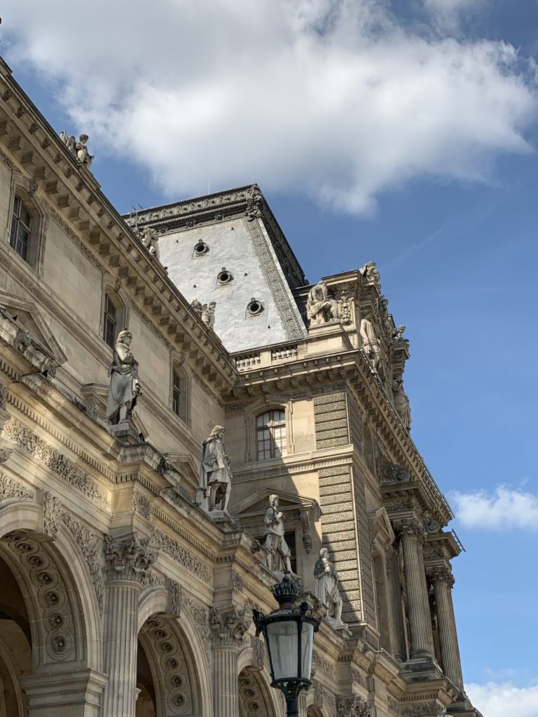 Louvre facade with arched windows and sculptural ornament