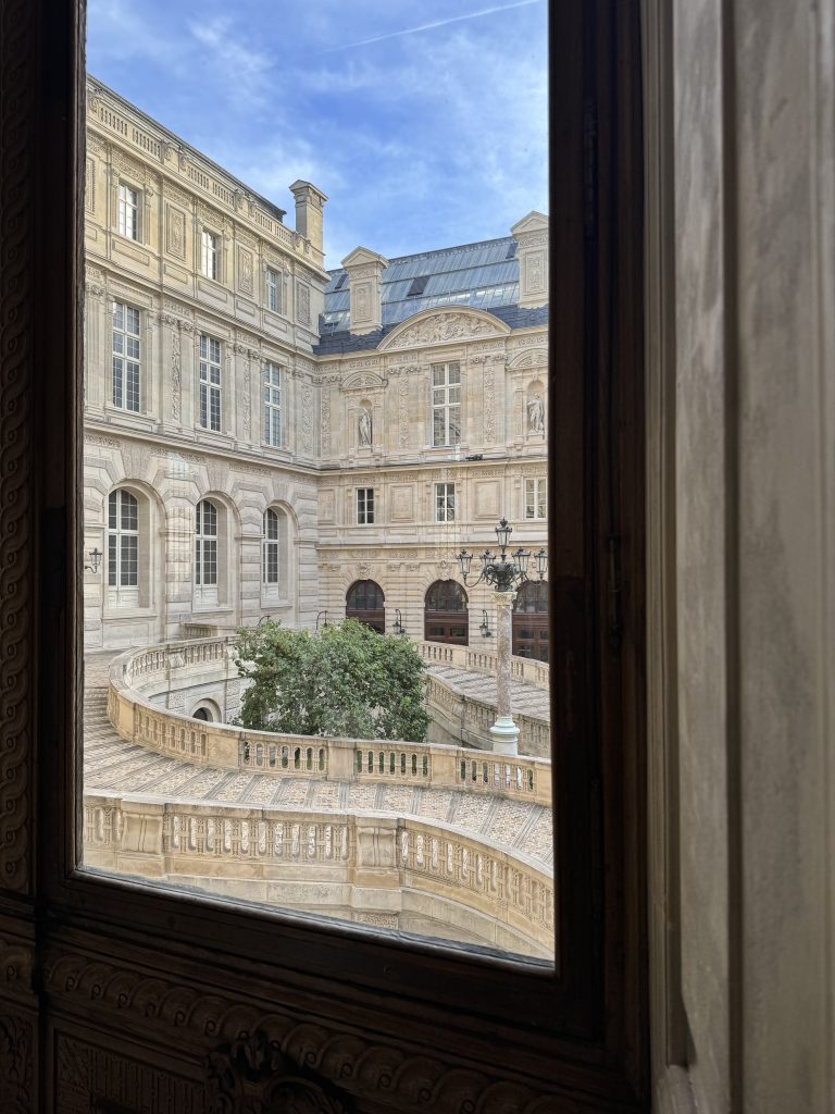 Louvre courtyard seen through a tall window