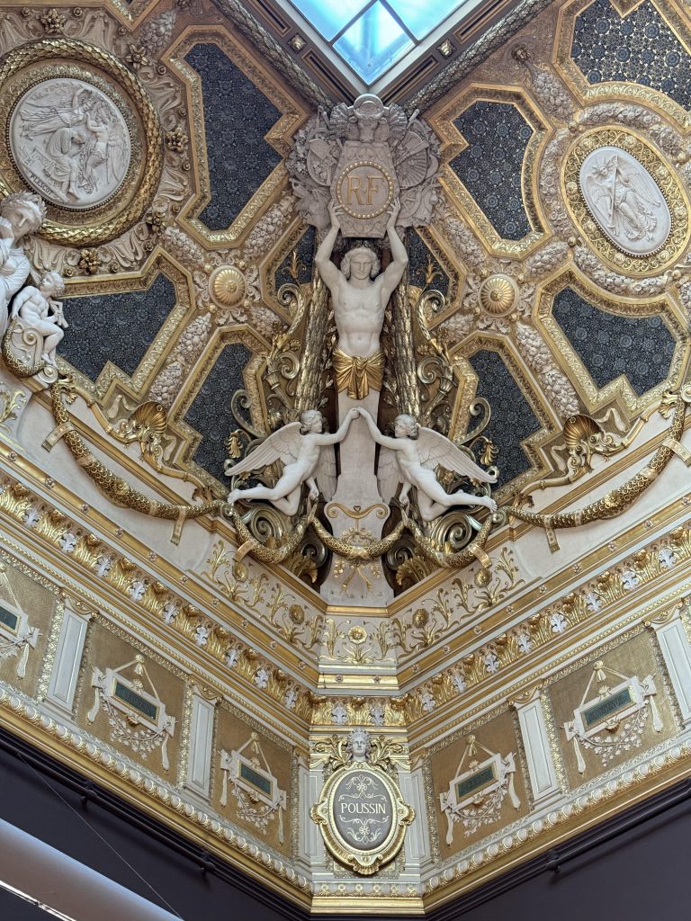 Ornate gilded ceiling with painted panels and sculptural figures