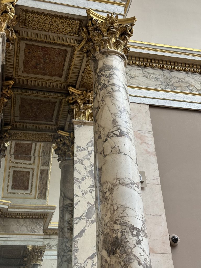 Veined marble column and richly ornamented interior at the Louvre