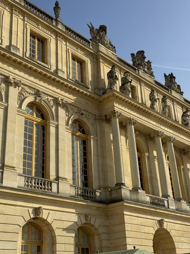 Sculpted stone facade and tall windows at the Palace of Versailles