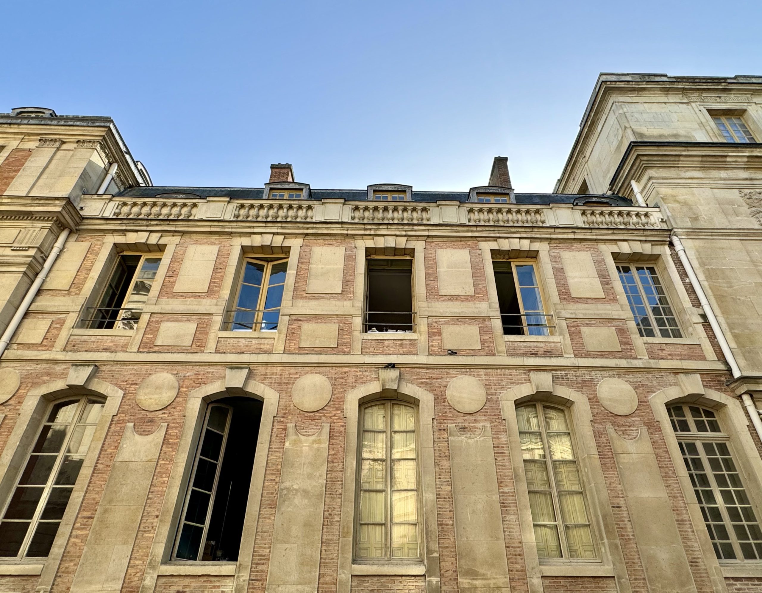 Red brick and limestone facade surrounding the palace courtyard
