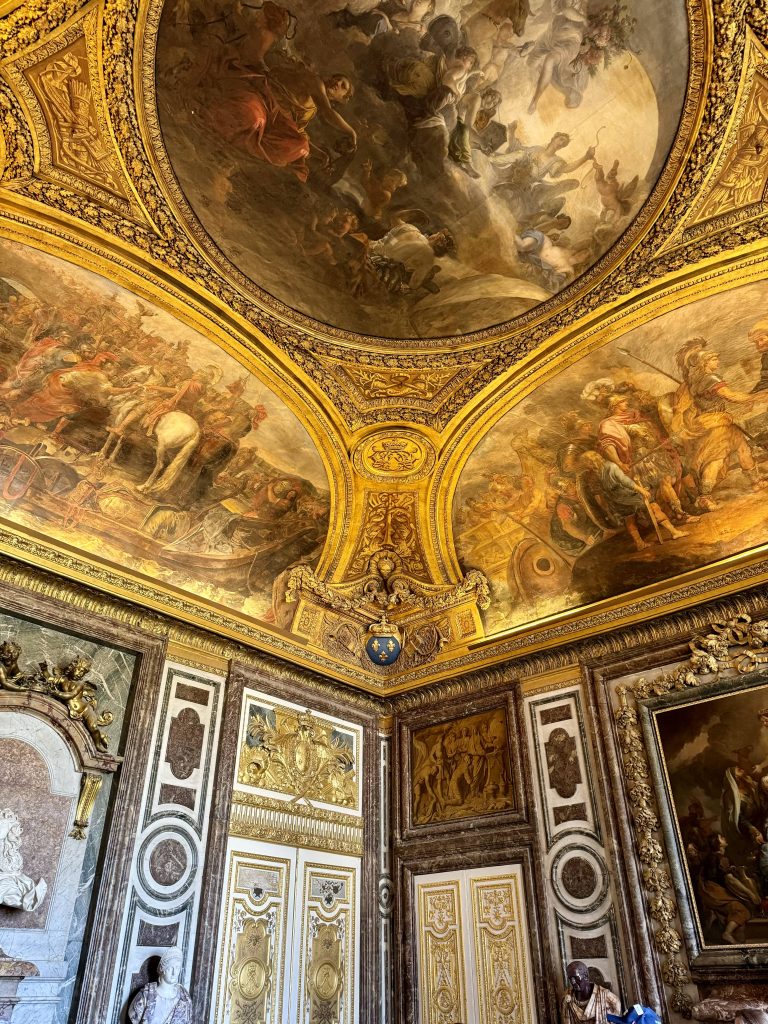 Gilded ceiling paintings above marble doorways
