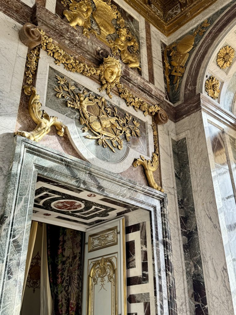 Ornate gilded relief above a marble doorway