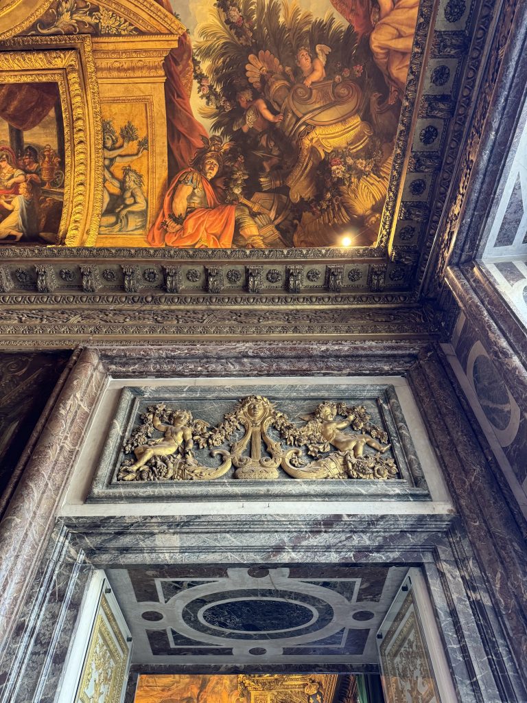 Painted ceiling and sculpted relief over a dark marble doorway