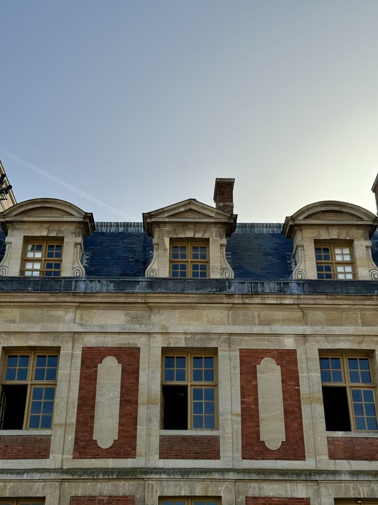 Roof dormers and stone pilasters above the brick palace facade