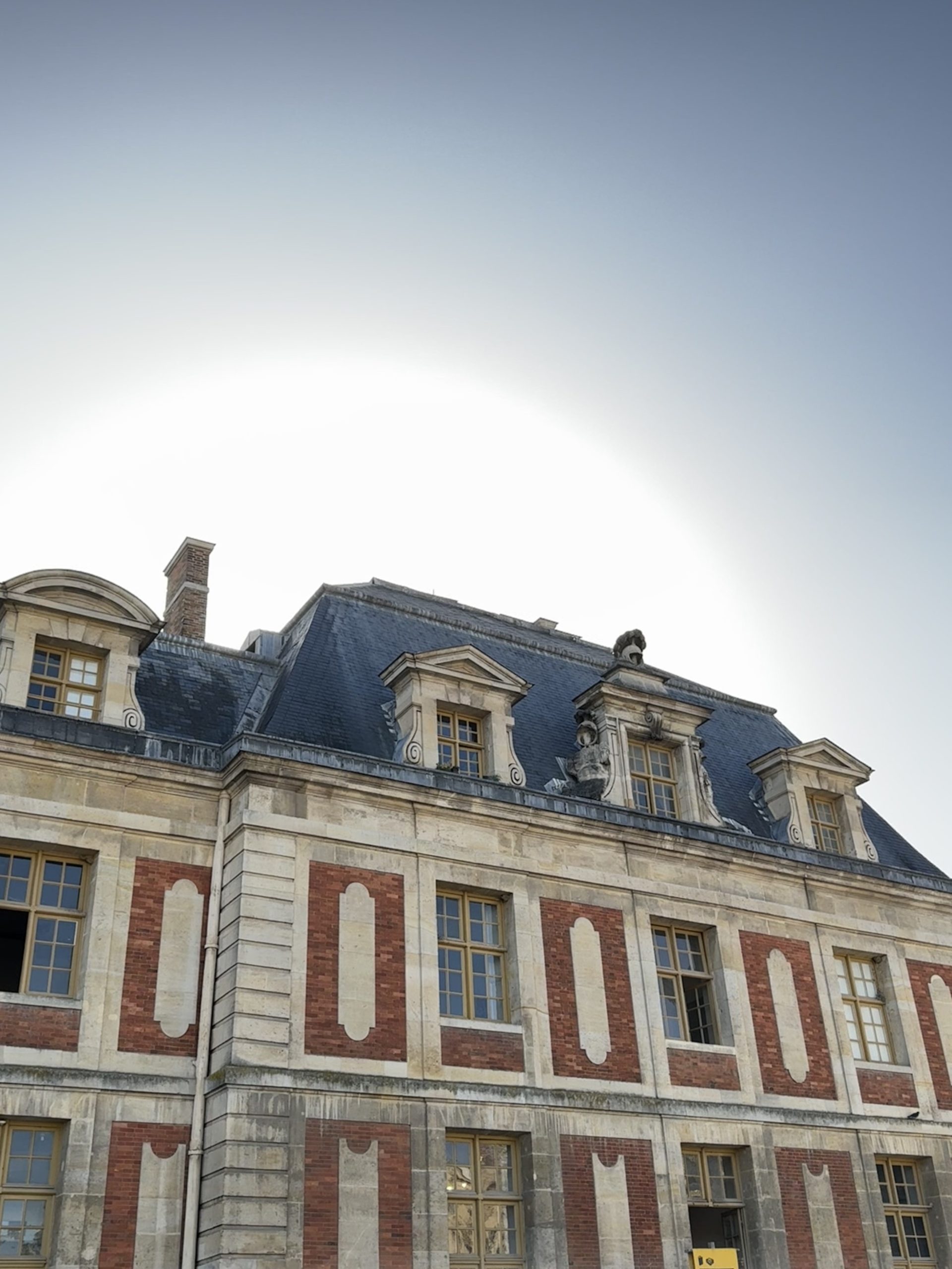 Sunlit roofline and ornate dormer windows over the palace courtyard
