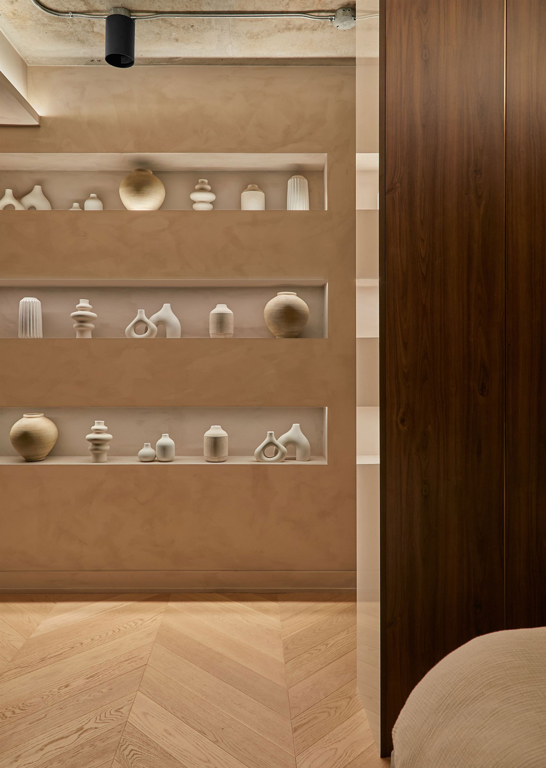 Warm timber cabinetry and sculptural display shelves