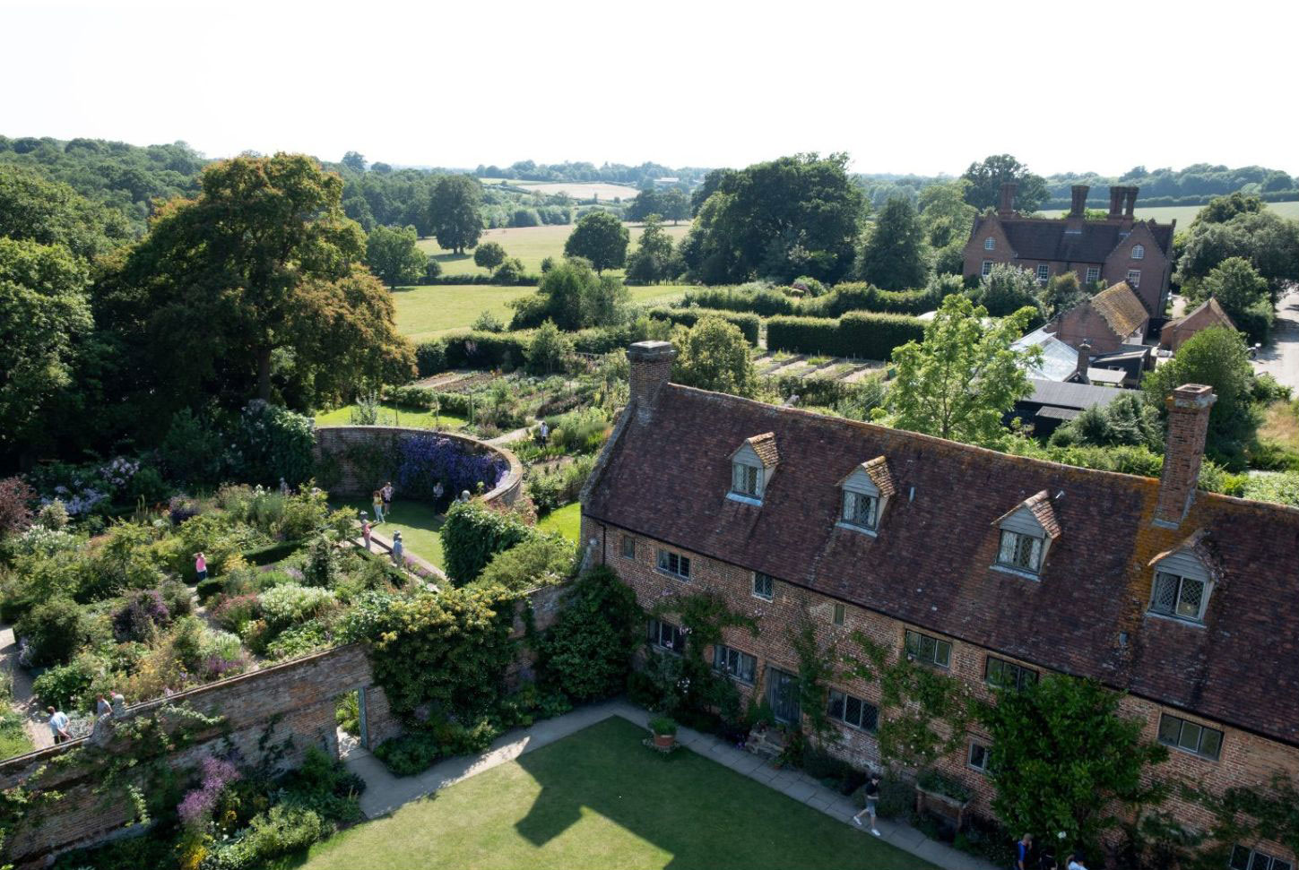 Aerial view of a traditional house within clipped gardens