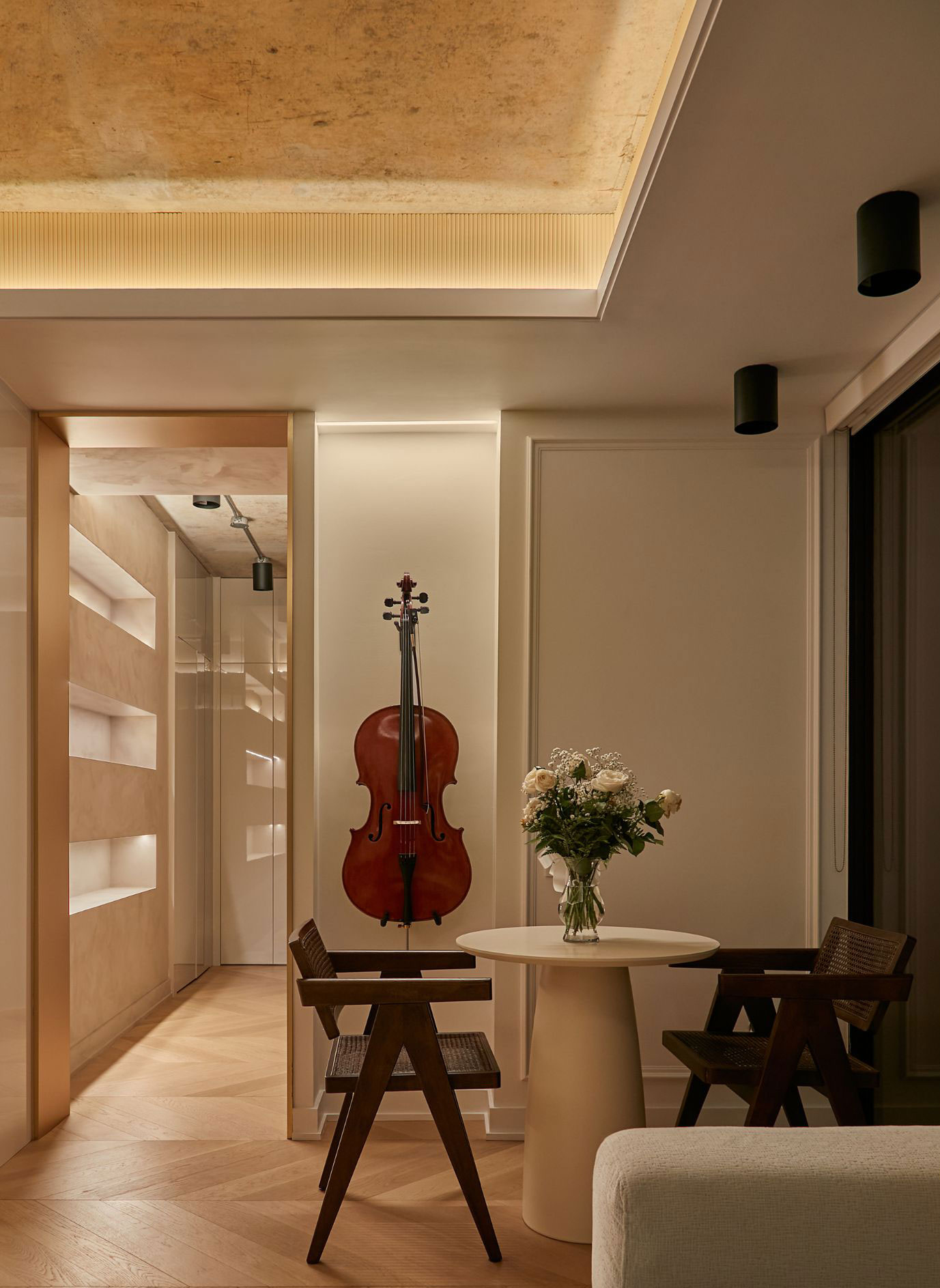 Cello beside a round table in a warmly lit interior