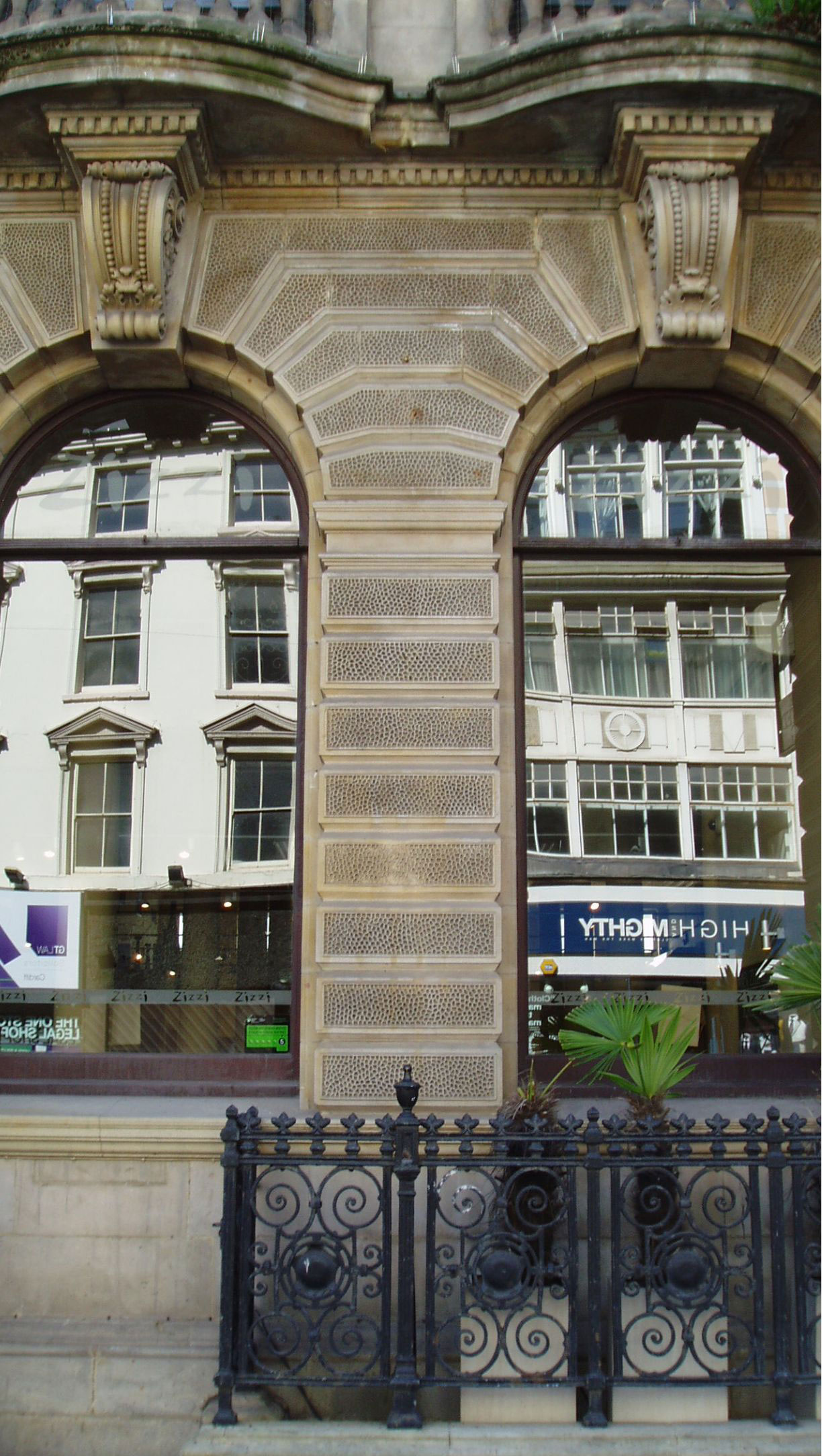 Carved stone and striped masonry around arched windows