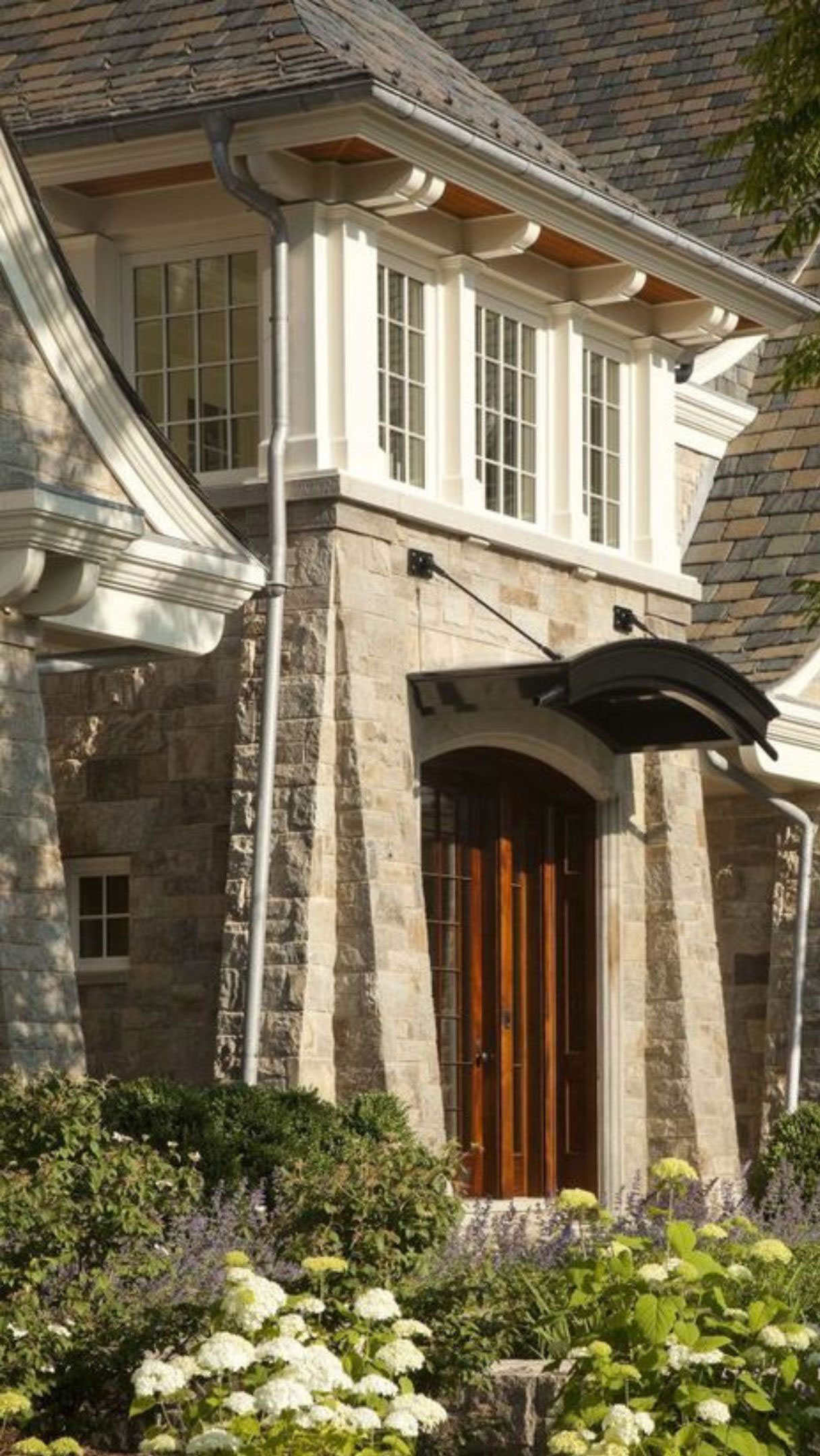 Tapered stone entrance surround beneath projecting windows