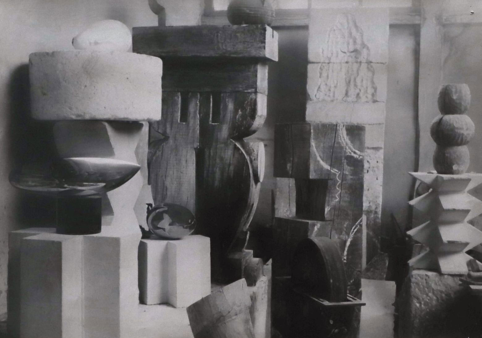 Black-and-white photograph of sculptures and carved pedestals