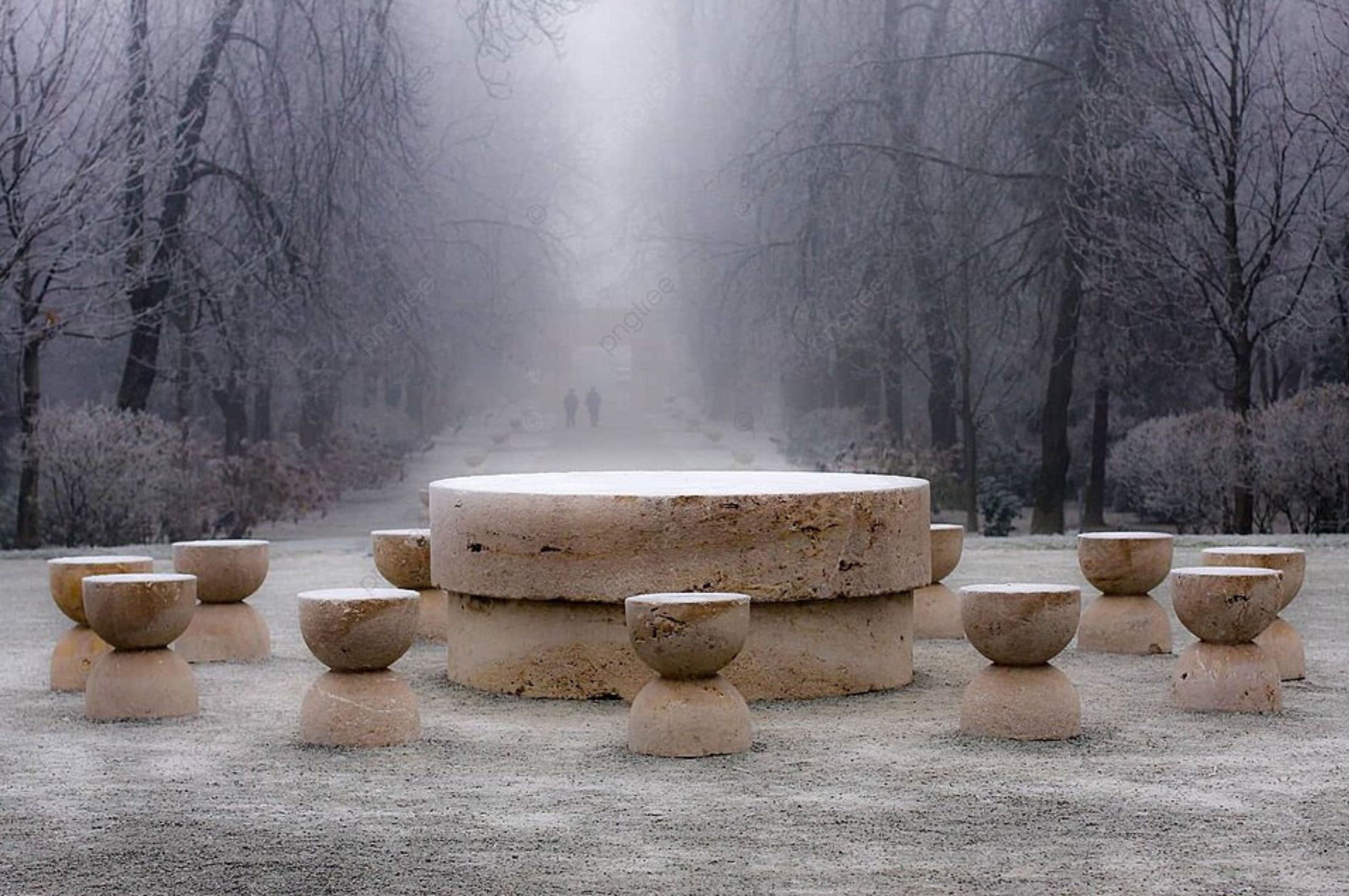 Circular stone table and stools along a wooded path