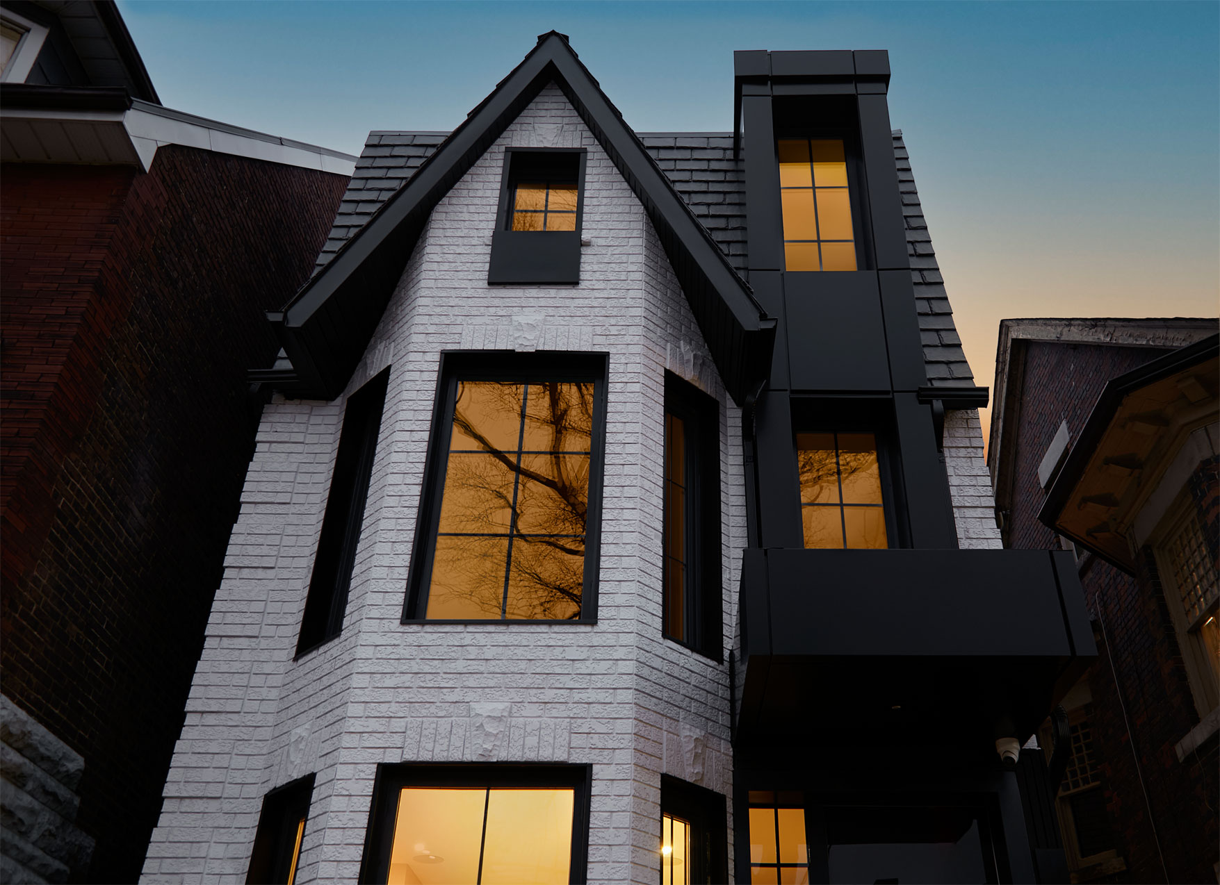 Close view of the white-brick gable and black metal window tower