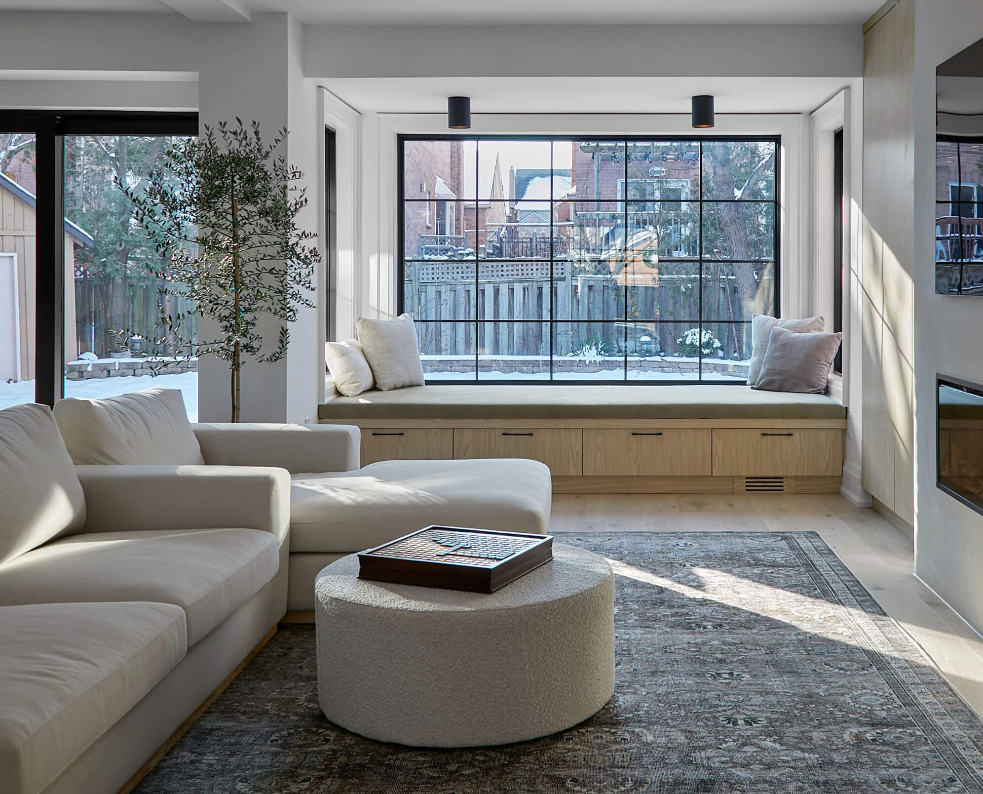 Sunlit sitting room with window seat and pale furnishings