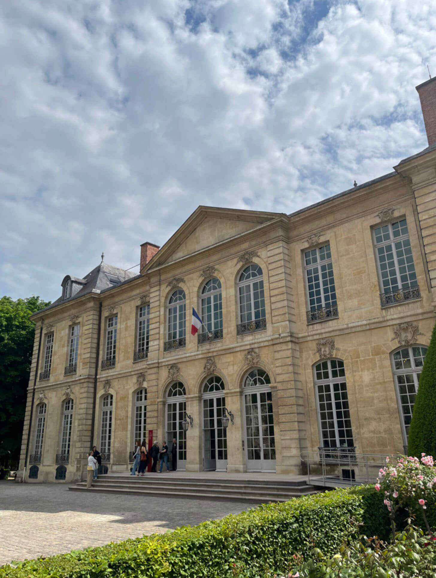 Classical stone facade of Musée Rodin beside its gardens