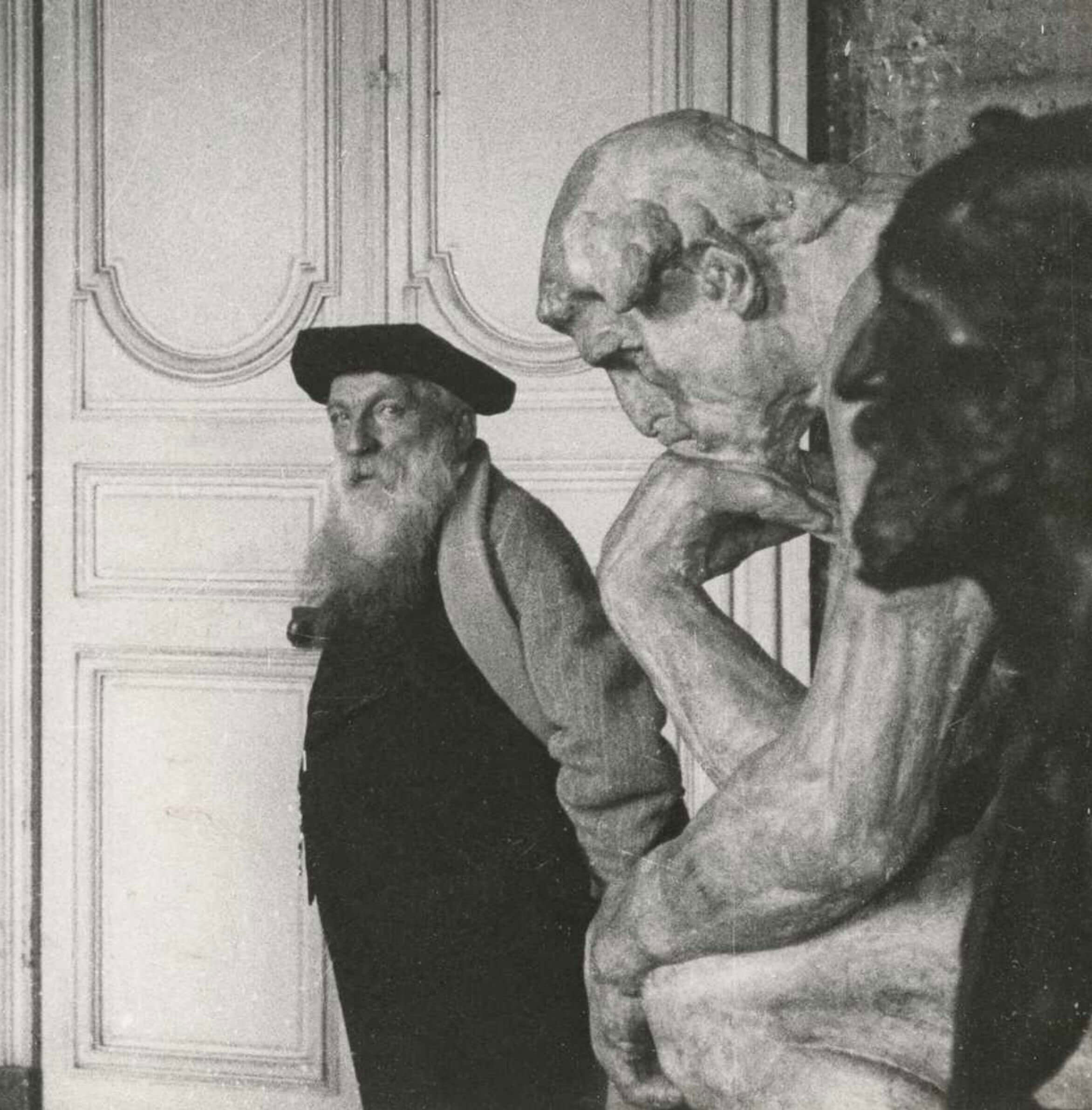 Archival portrait of Rodin beside his sculpture