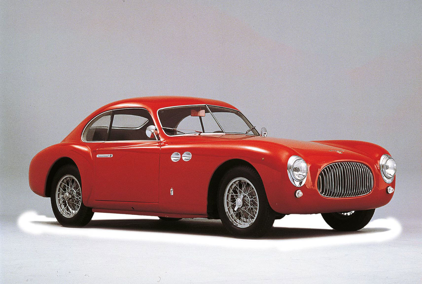 Red classic sports coupe in a studio