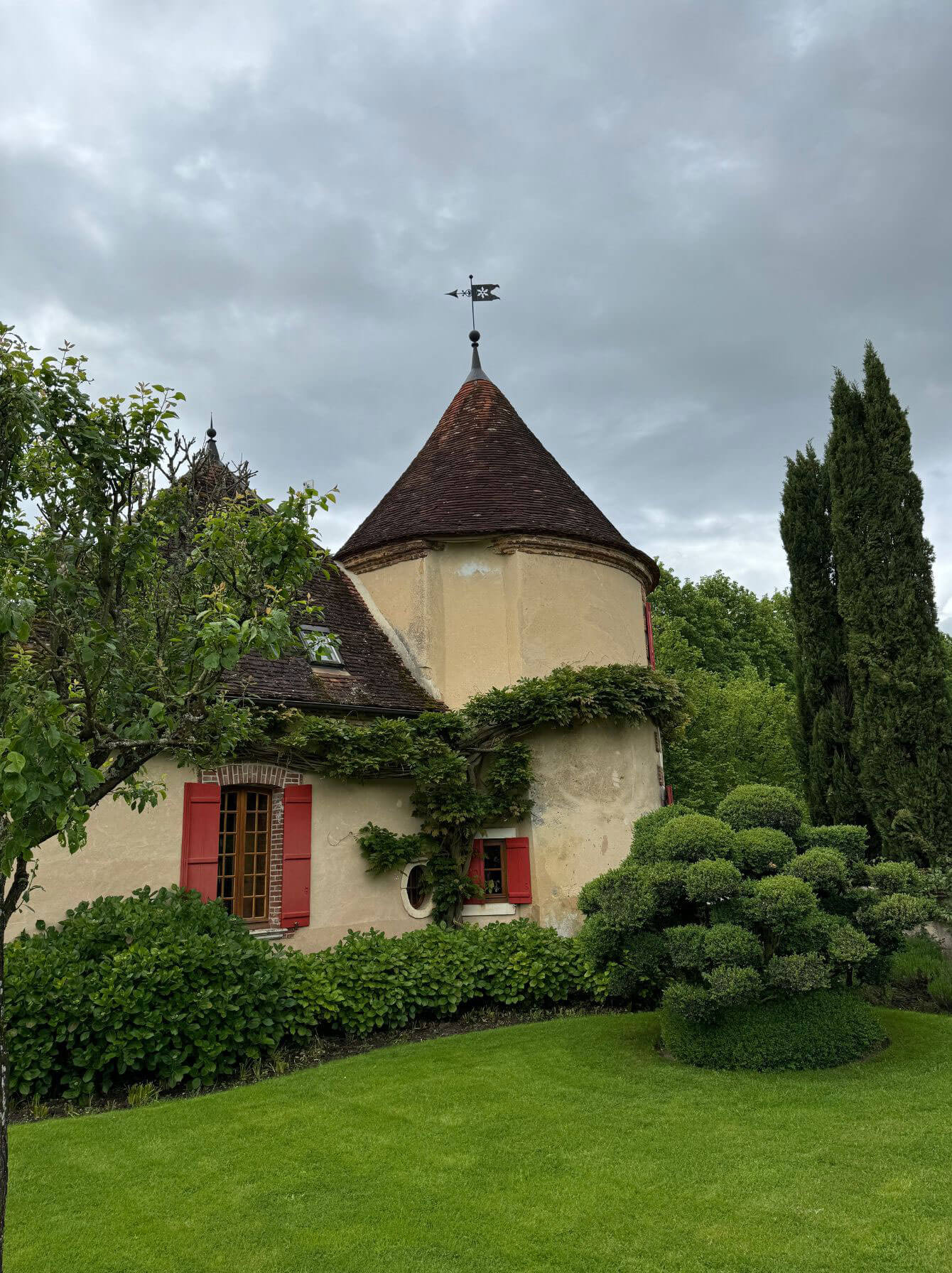 Round stone tower surrounded by a green garden