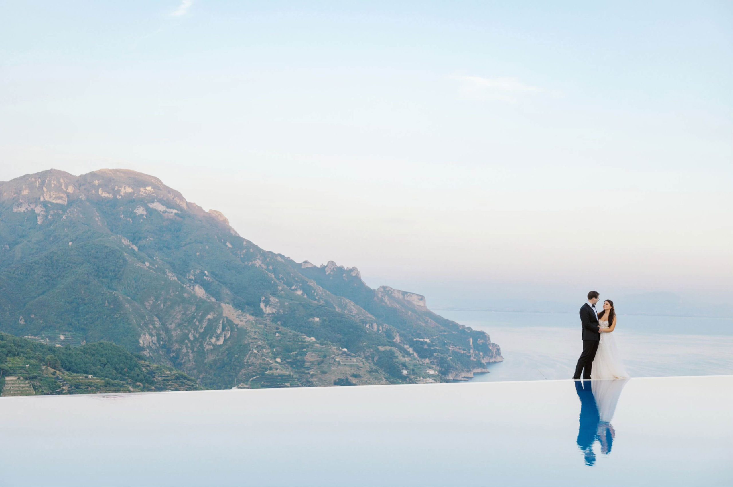 Figure beside an infinity pool overlooking the coast