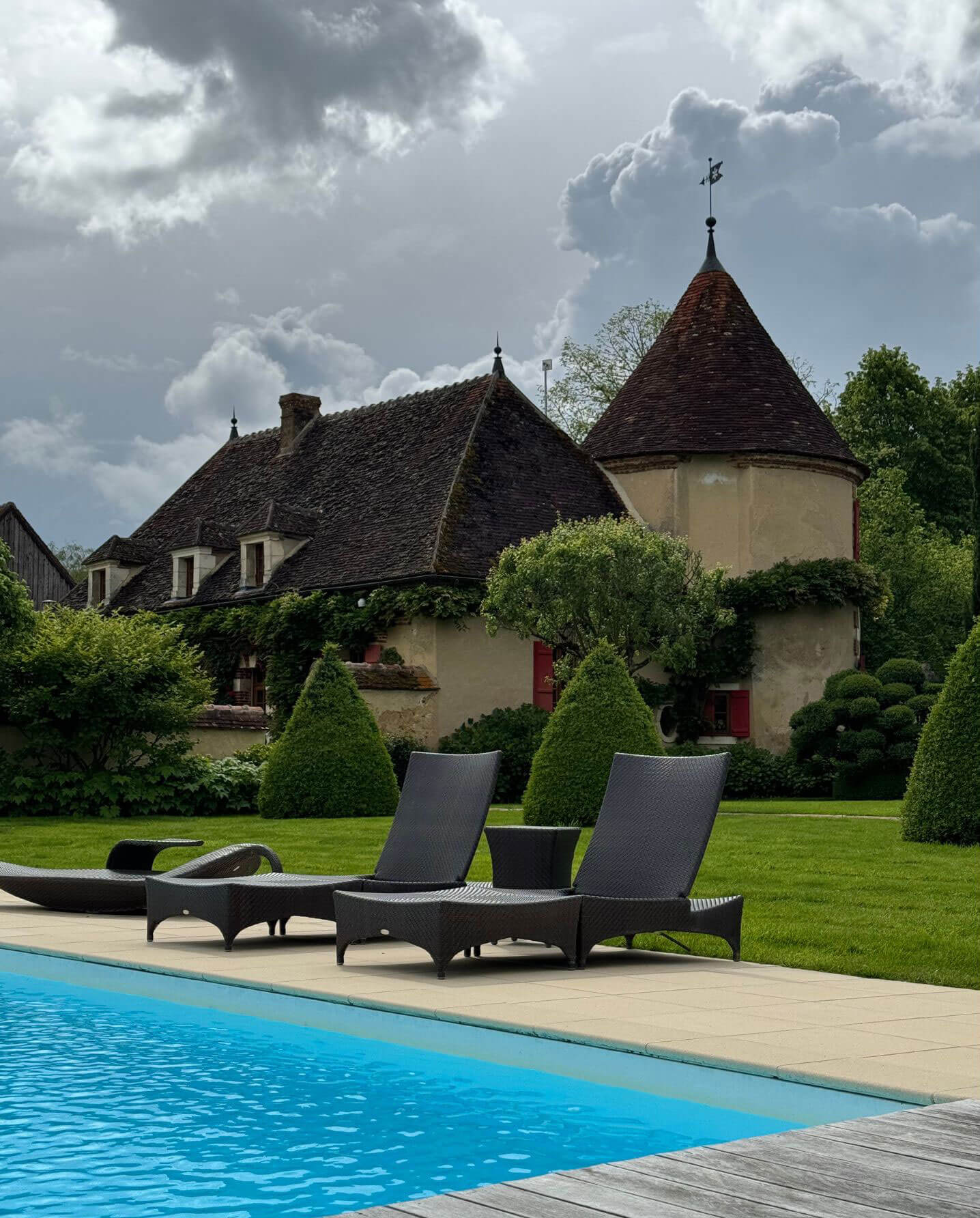 Poolside recliners beneath the manor turret