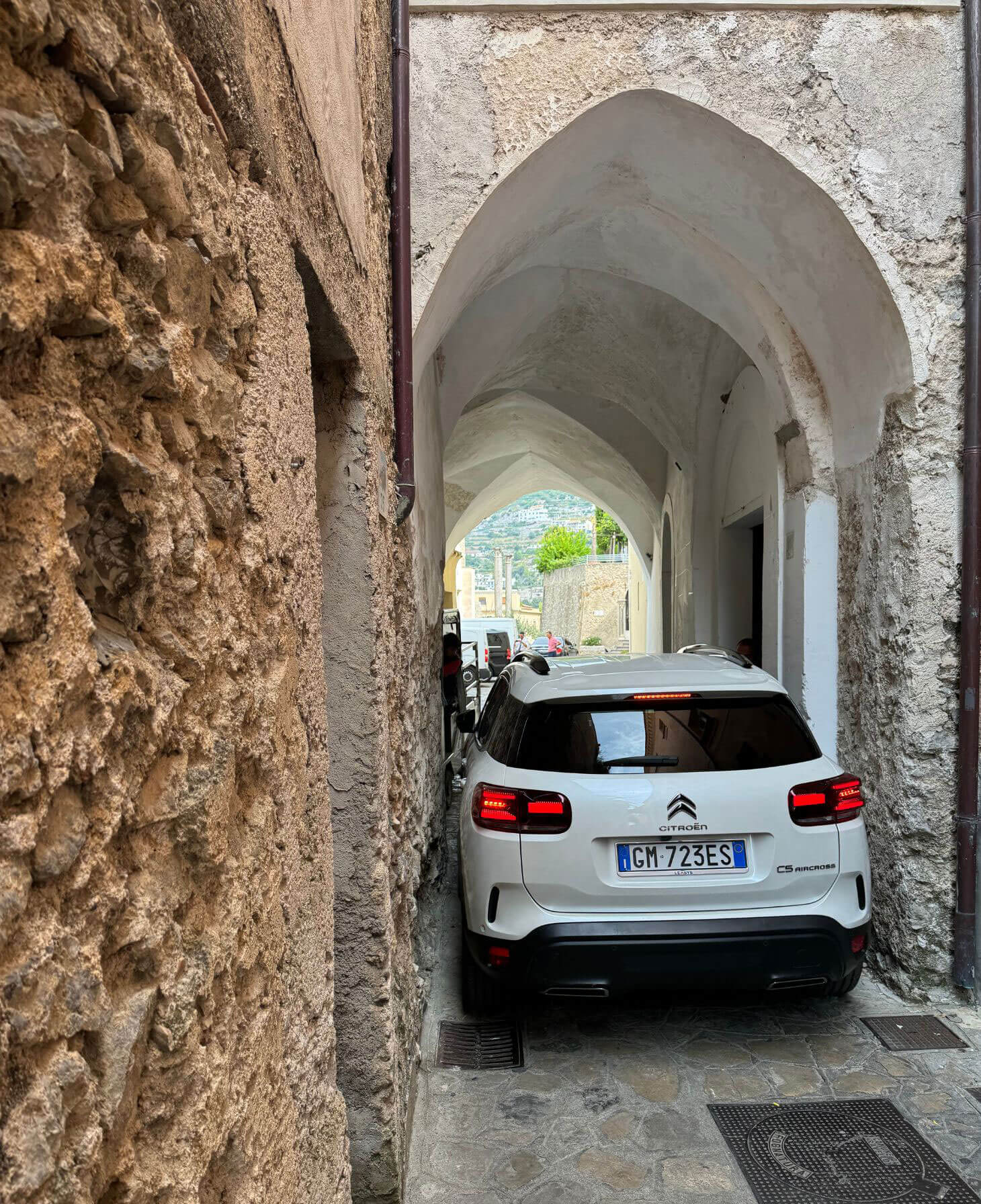 Car beneath a tall vaulted stone passage