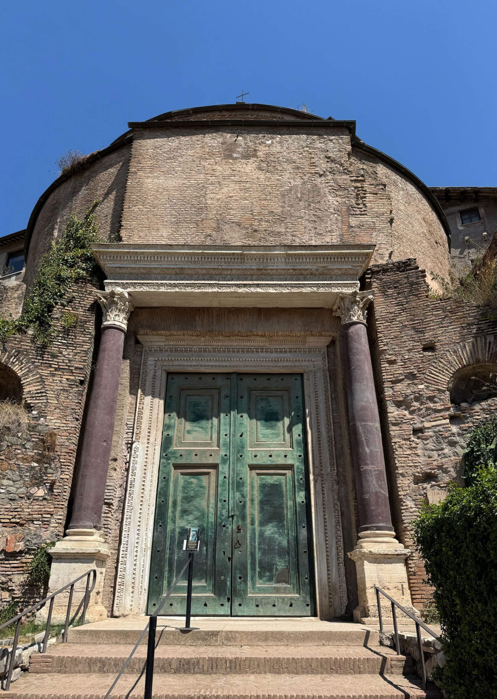 Bronze doorway framed by coloured stone columns