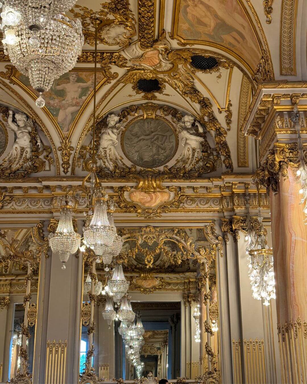 Gilded palace interior with chandeliers and painted ceilings