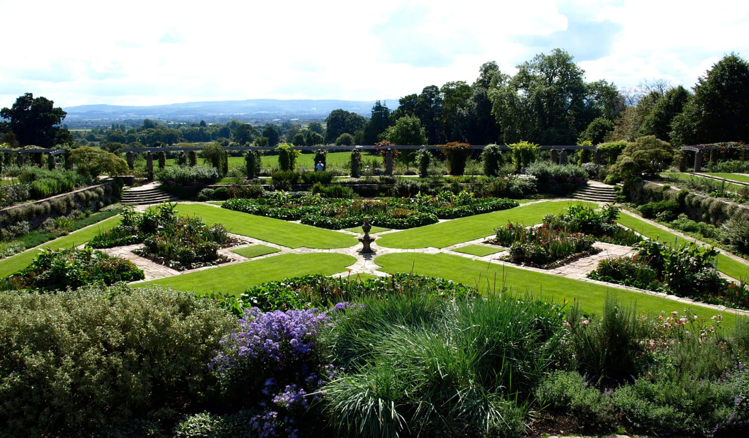 Formal garden divided into beds by straight paths and hedges