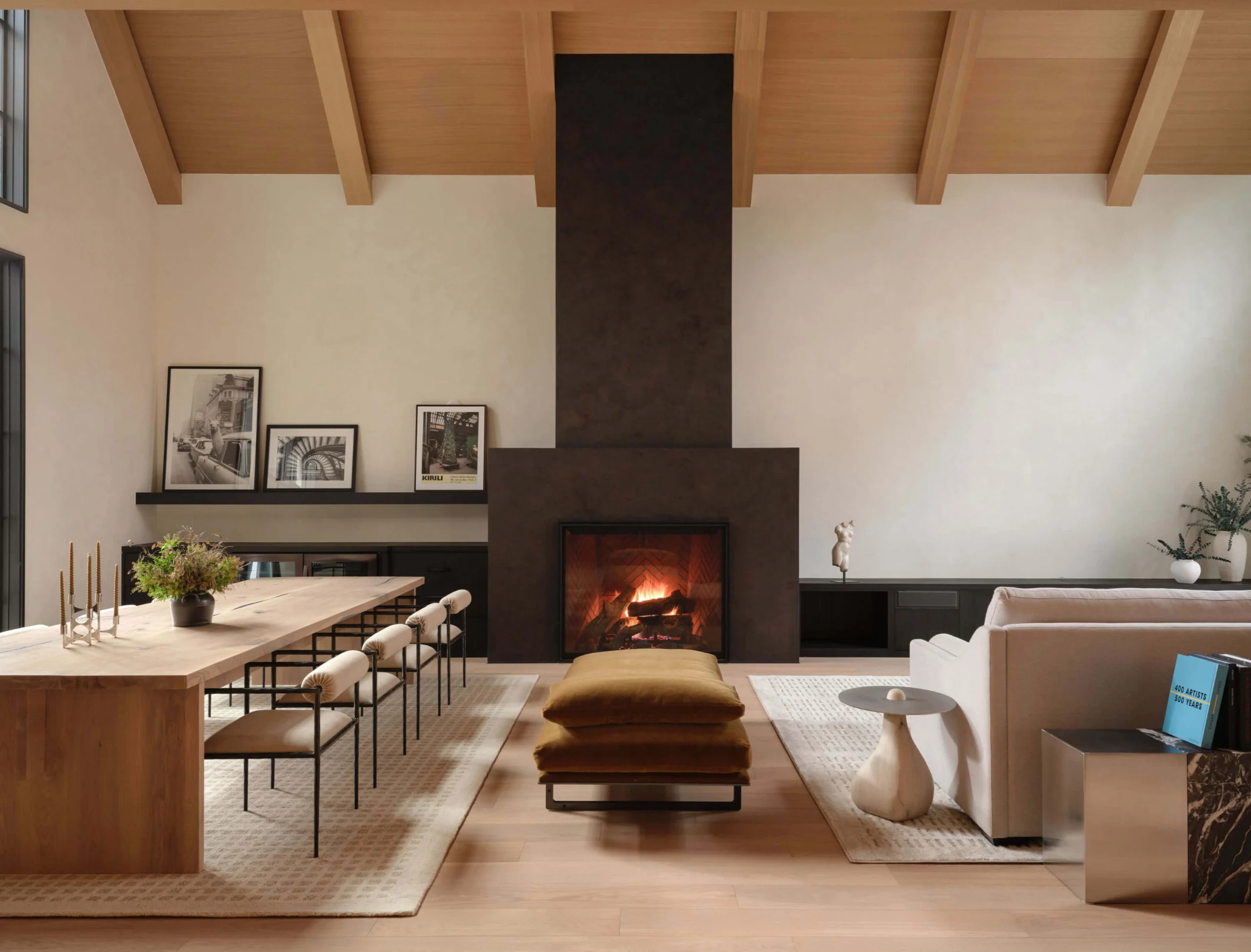 Curated living room with a sculptural staircase, fireplace and warm furnishings