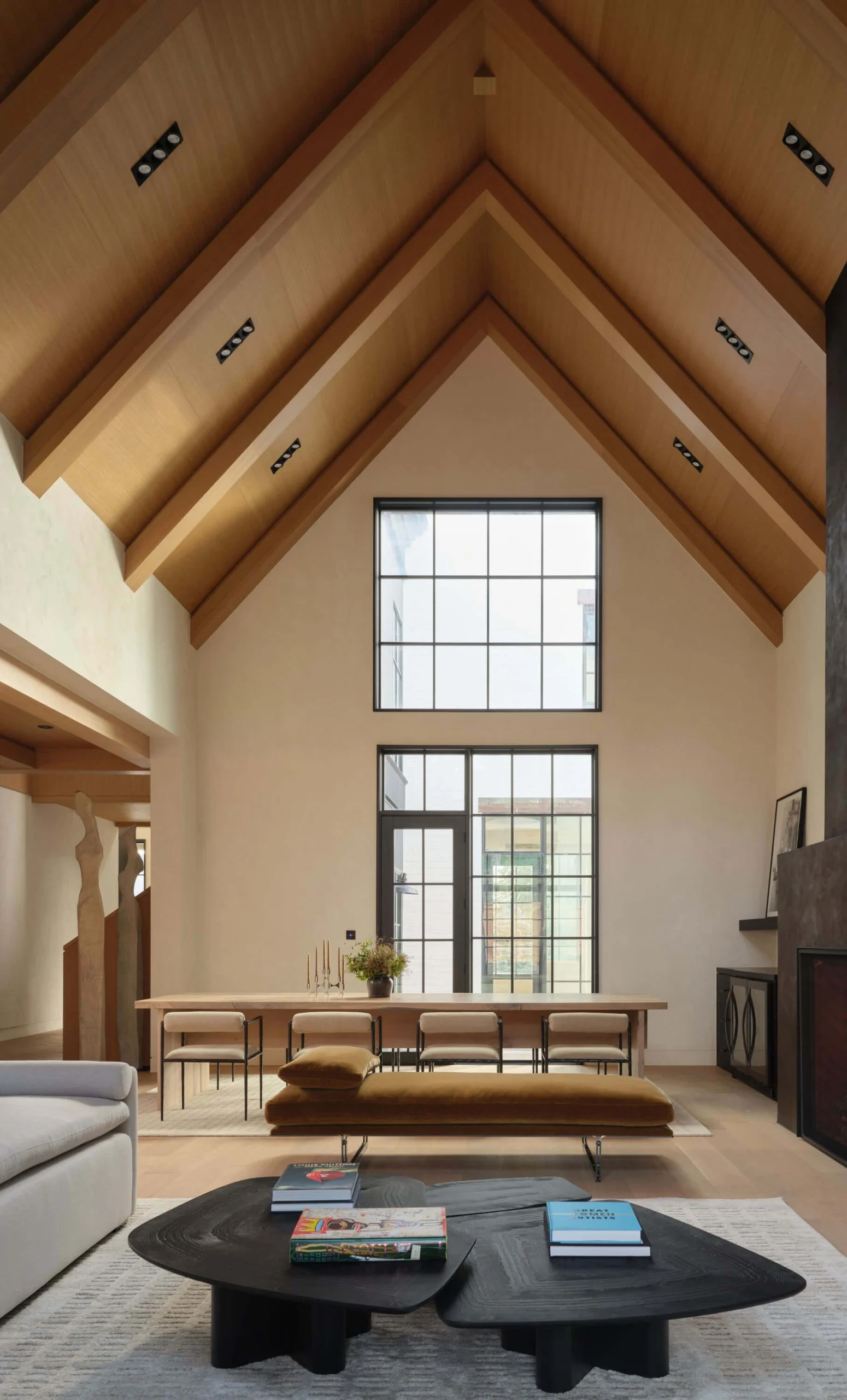 Double-height living room with curated seating and timber ceiling