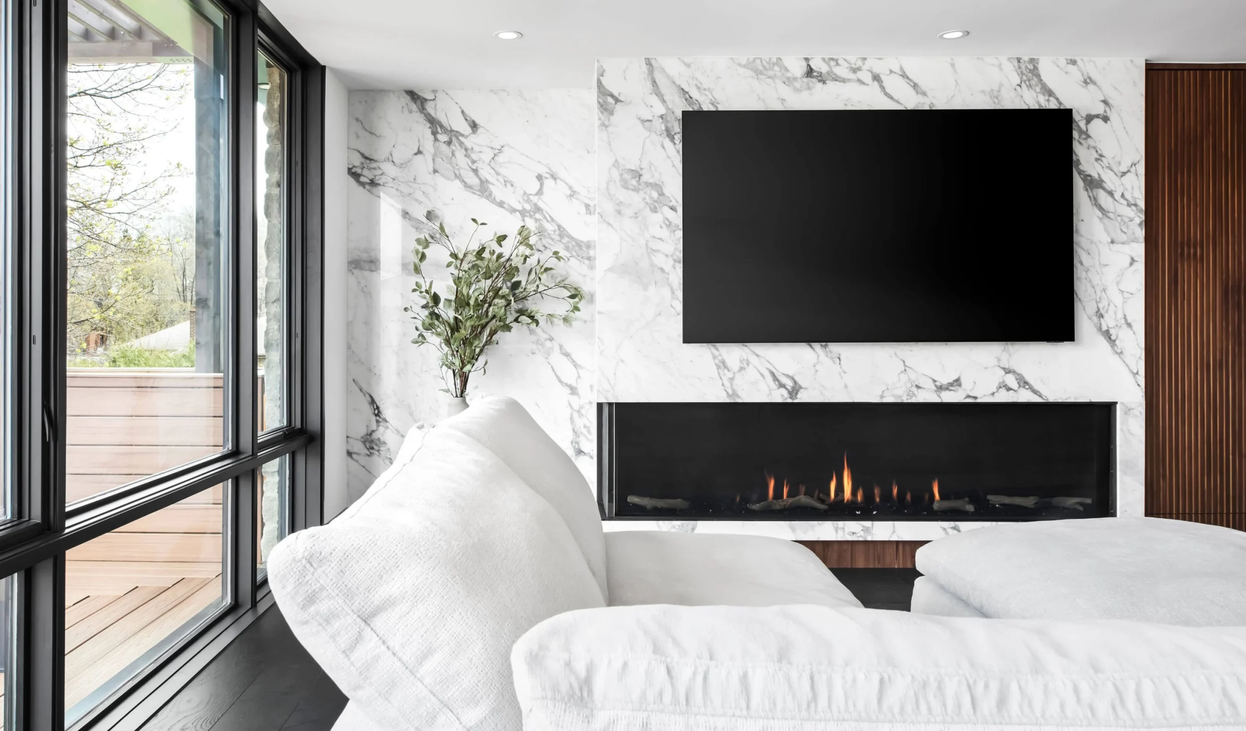 Bedroom with a fireplace, marble feature wall and layered textiles