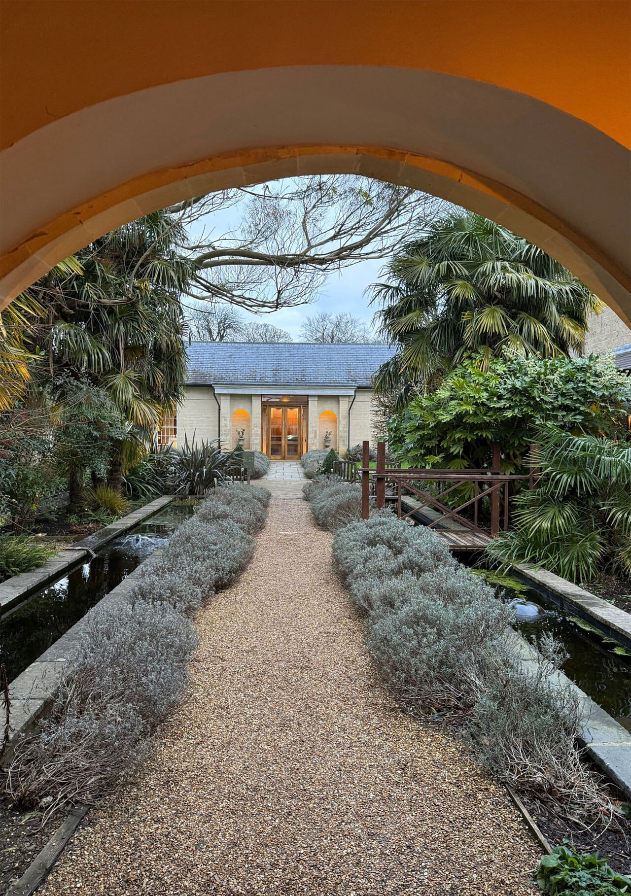 Arched passage framing a gravel garden path at Lucknam Park