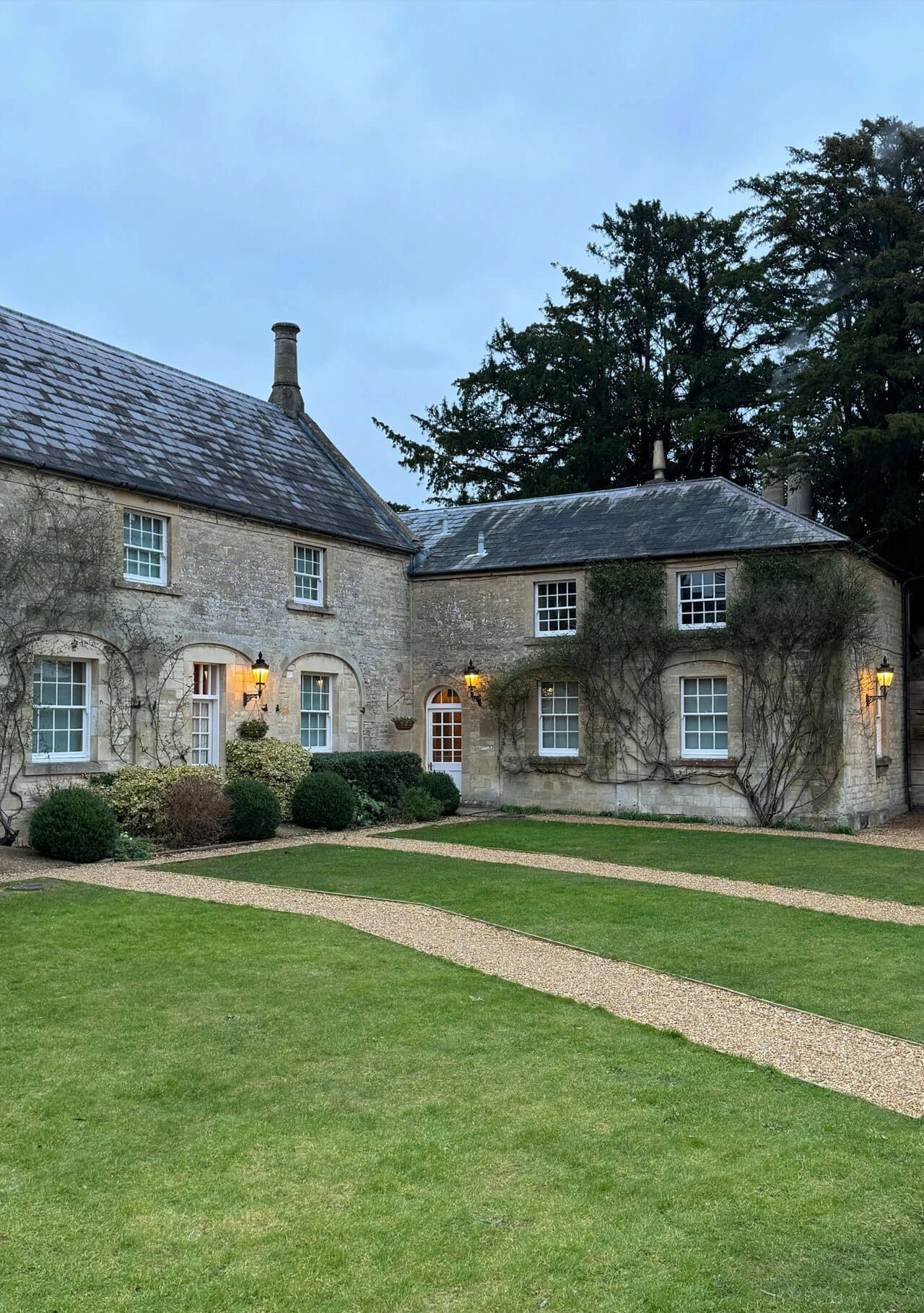 Stone courtyard buildings beside a gravel path
