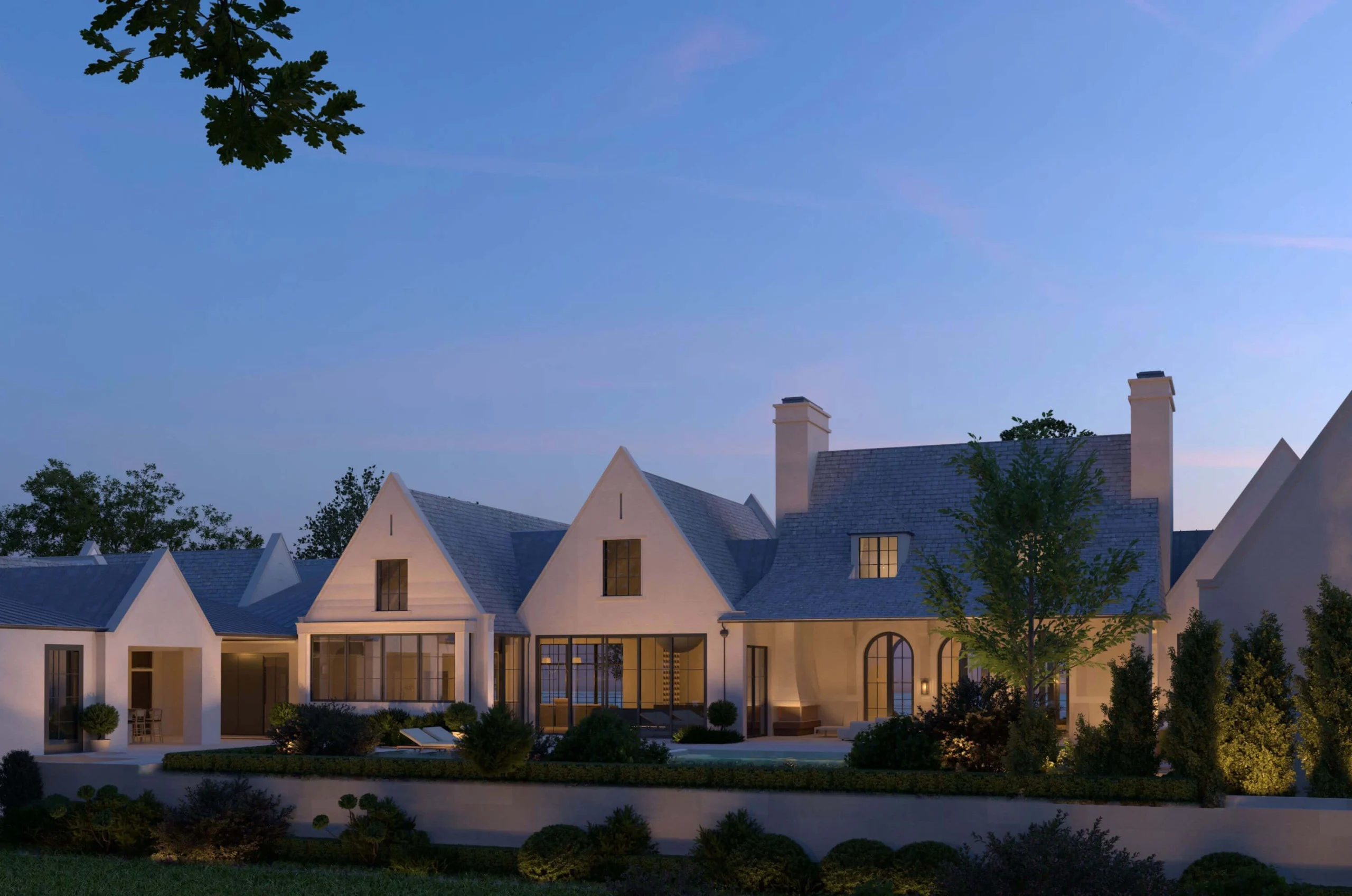 Tudor Country Home rear facade illuminated at dusk