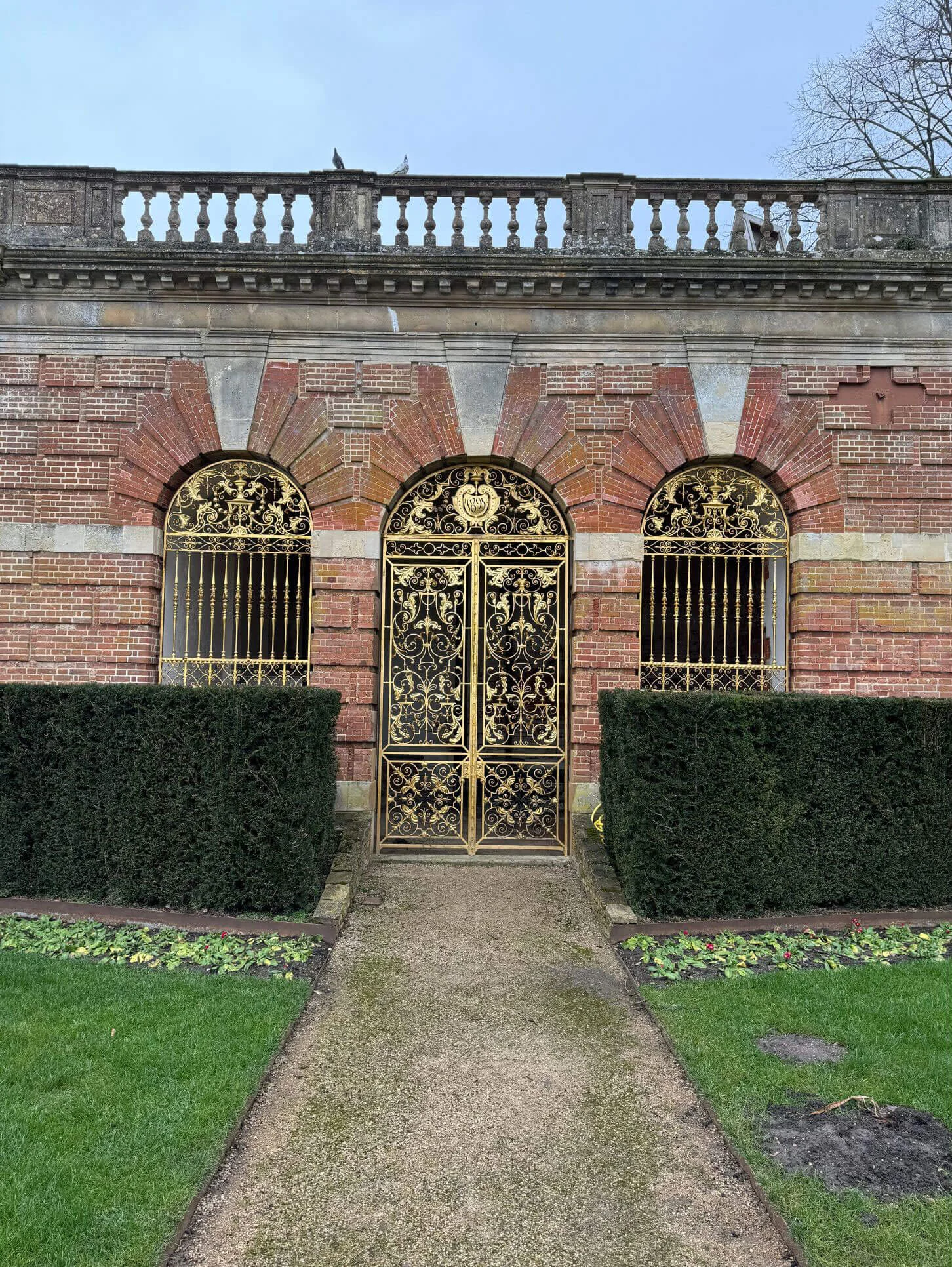 Ornate iron gate set in a patterned brick wall