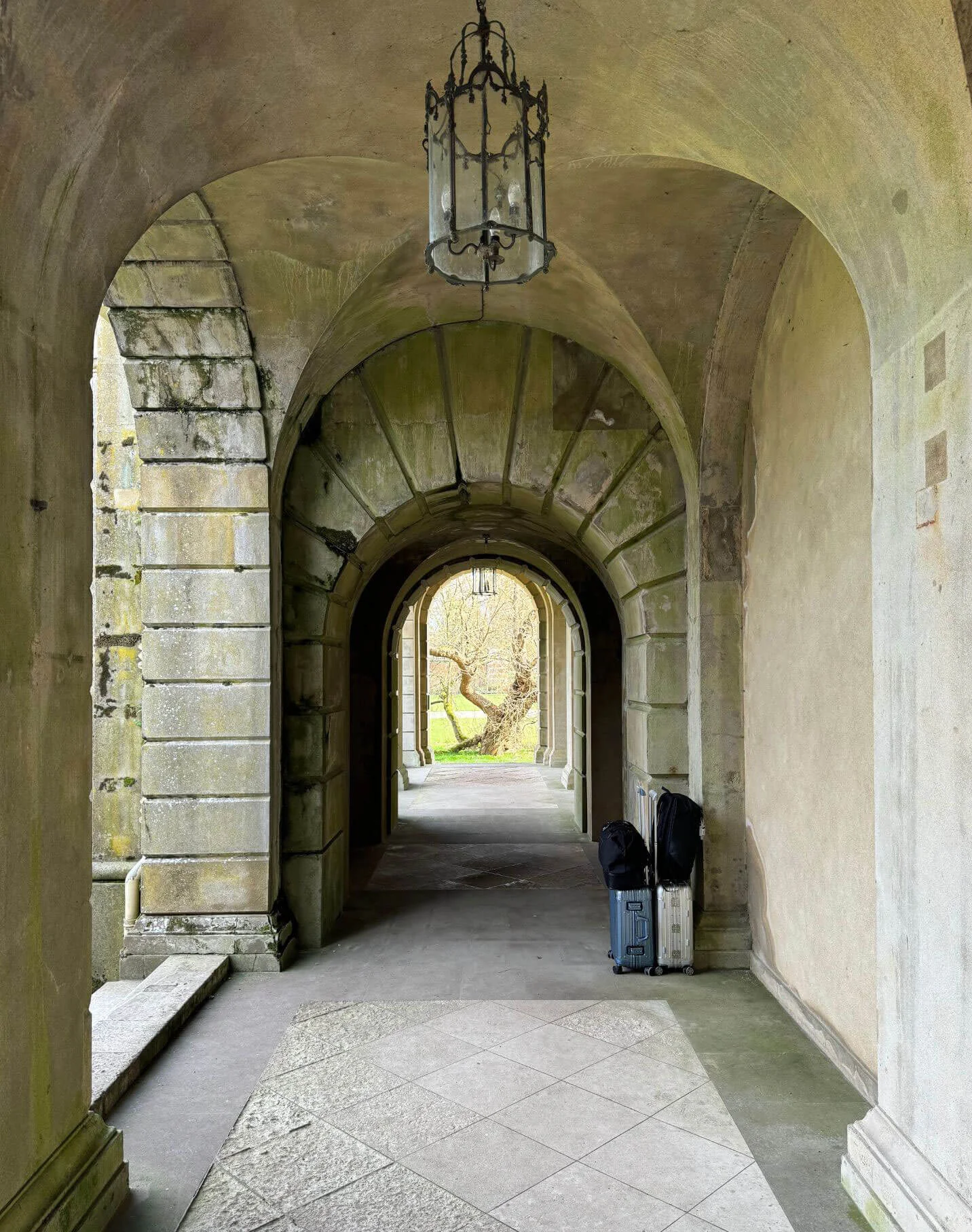 Vaulted stone passage framing a distant garden view