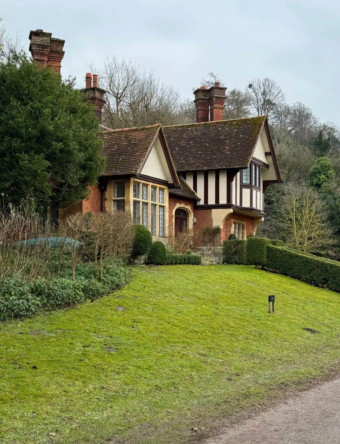 Half-timbered cottage beside a riverside lawn