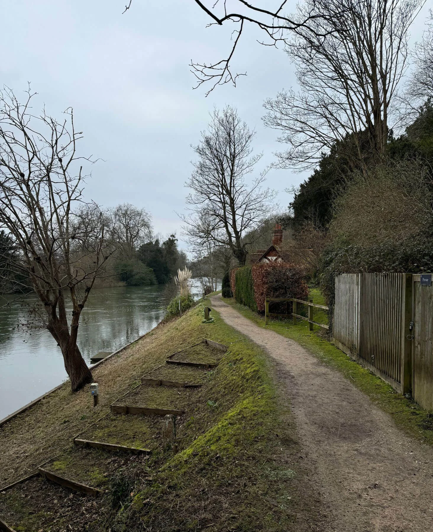 Riverside path beside cottages and bare trees