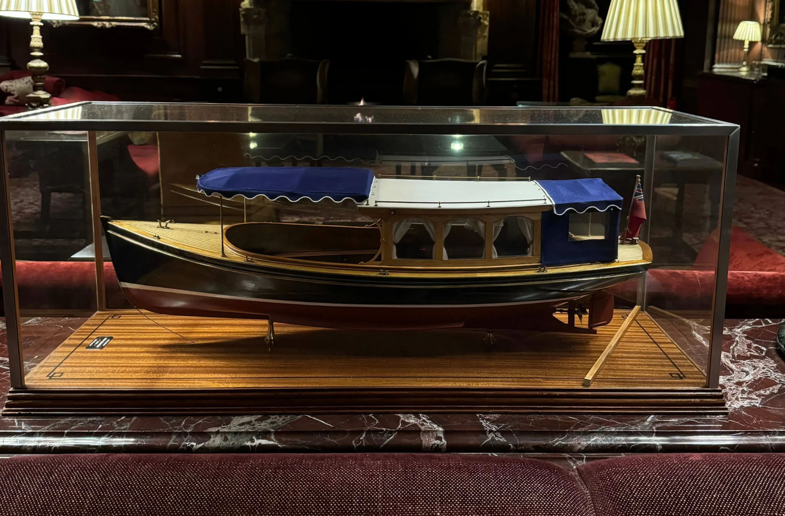 Detailed model of a river launch in a glass display case
