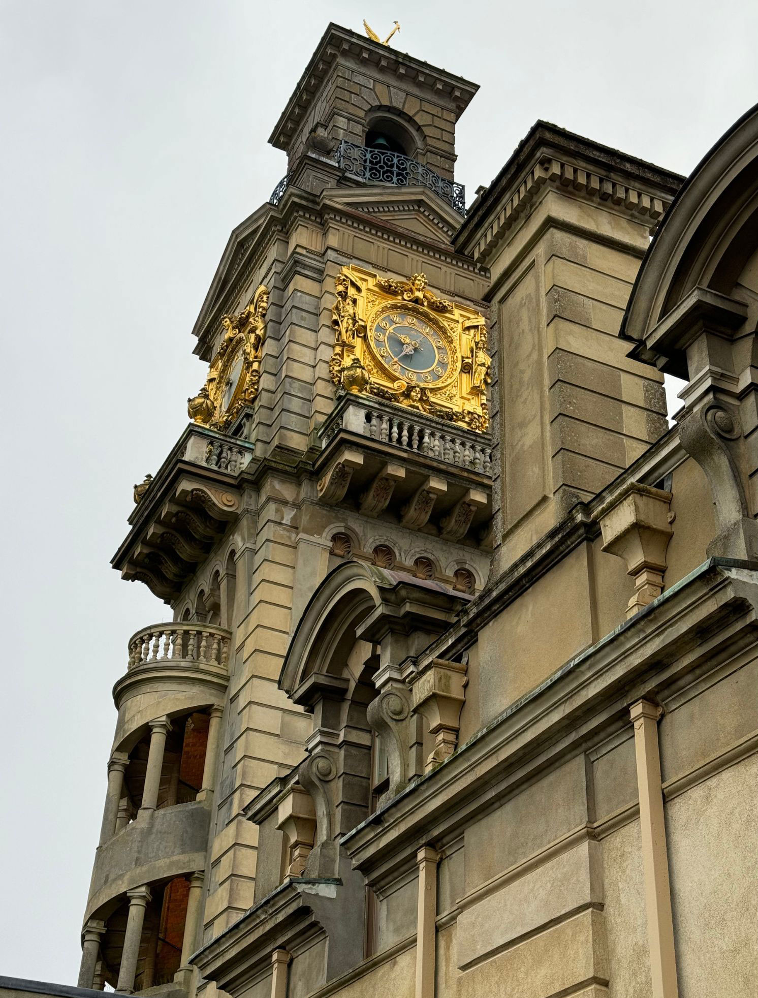Ornate gilded clock on a stone tower