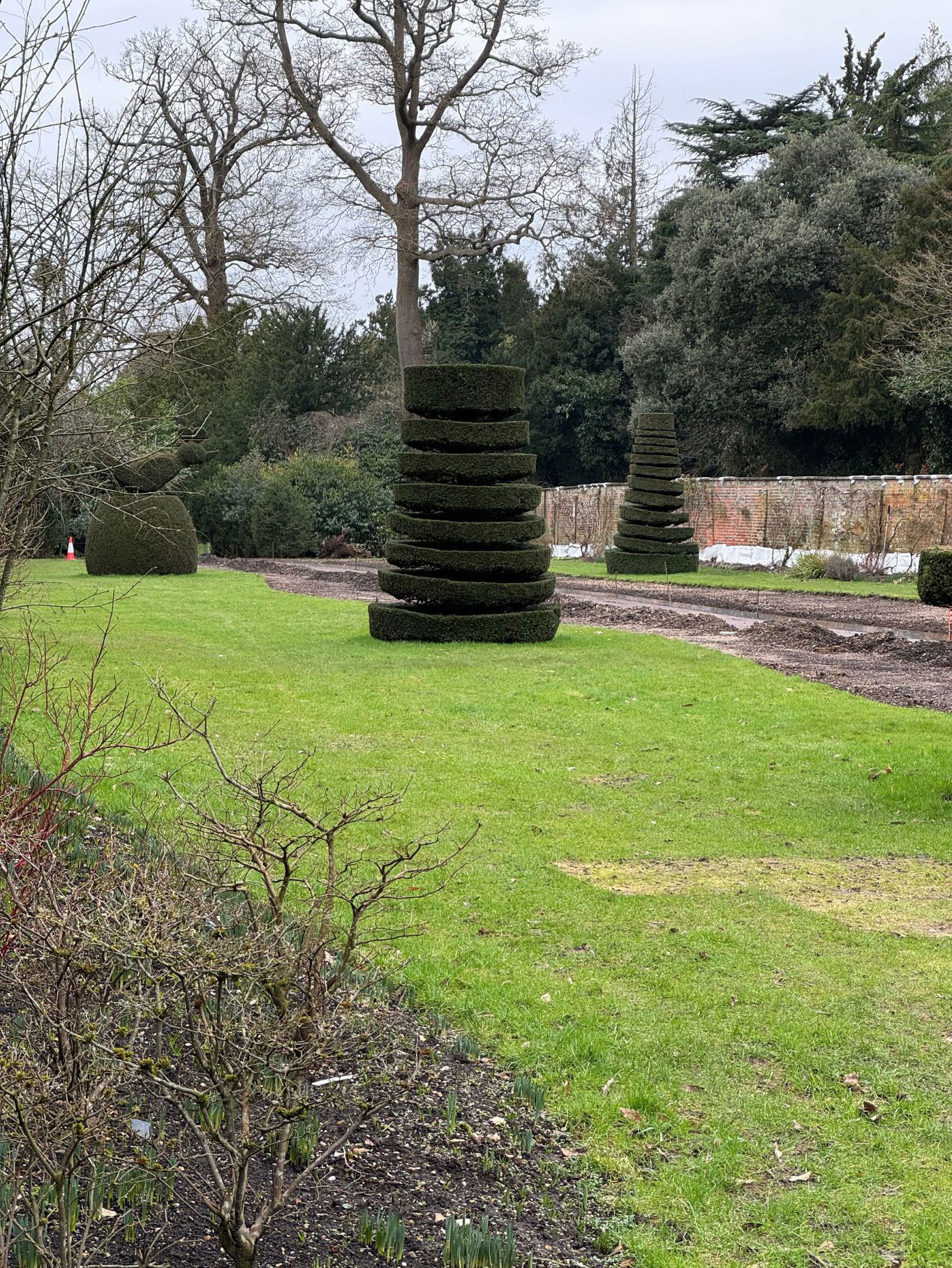 Tiered clipped topiary standing in a garden lawn