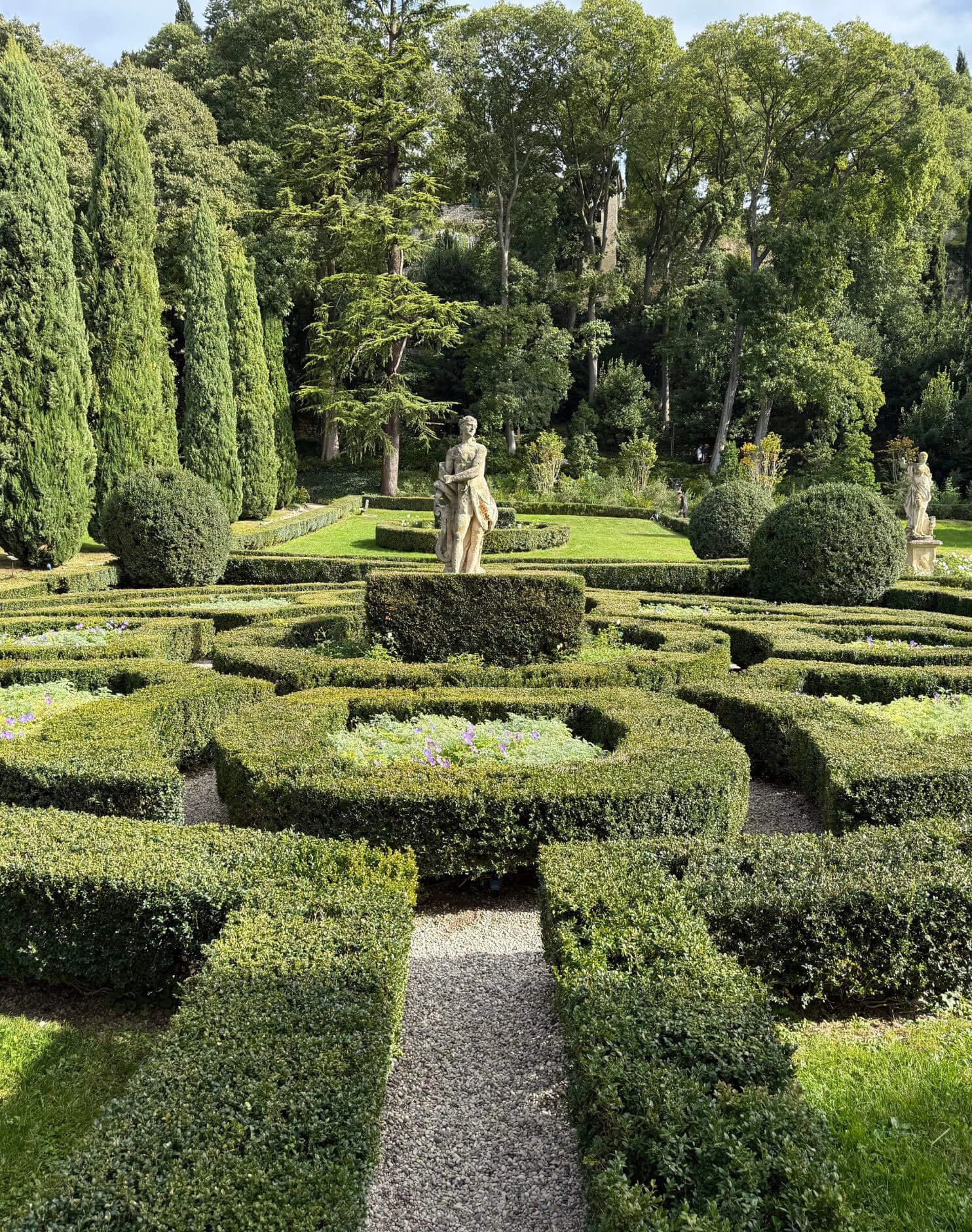 Geometric parterres surrounding a central garden statue