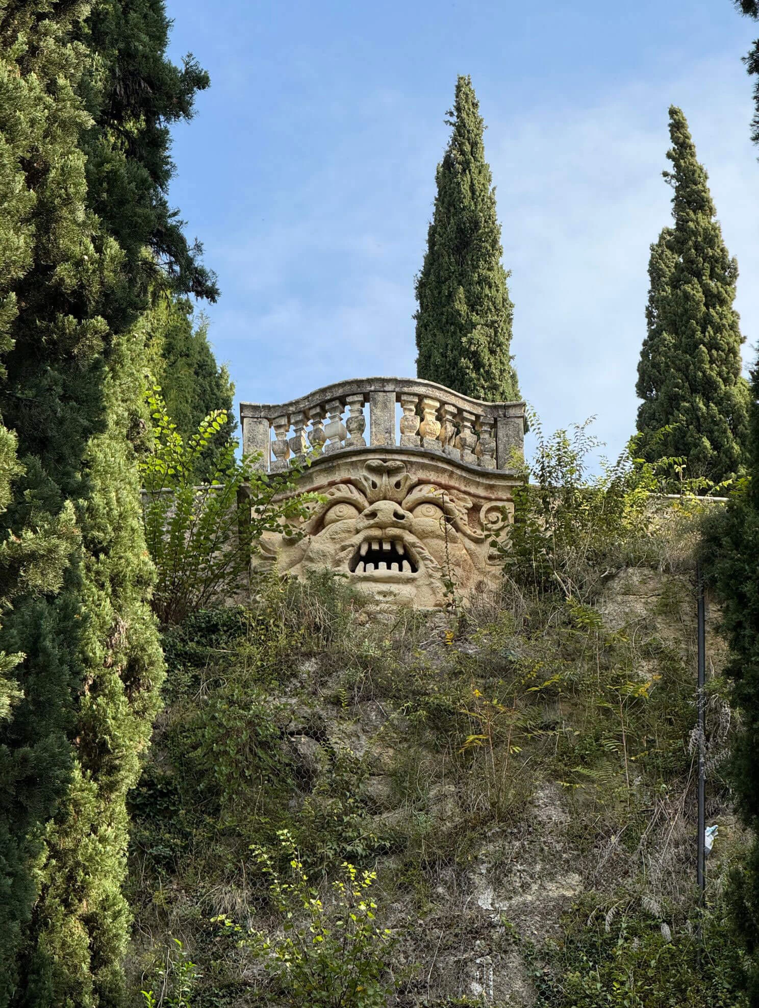 Grotesque stone mask beneath a balustraded terrace