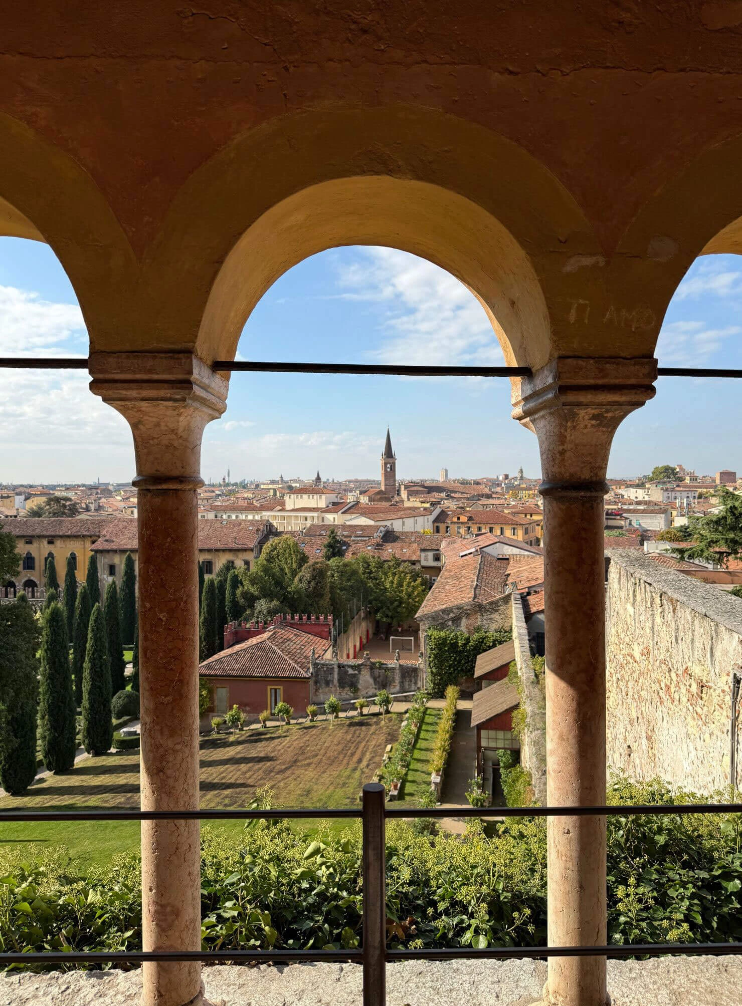 Arched loggia framing Verona rooftops and gardens